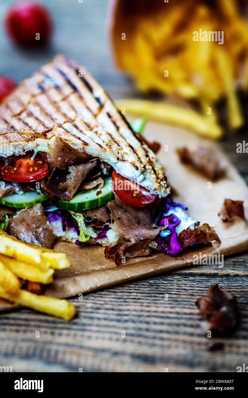 Faire don de kebab avec des légumes et des frites sur une table en bois Banque D'Images