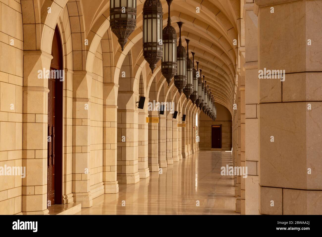 Arcades avec rangée de lampes ou de lanternes à la grande mosquée du Sultan Qaboos, à la périphérie de Nizwa en Oman Banque D'Images