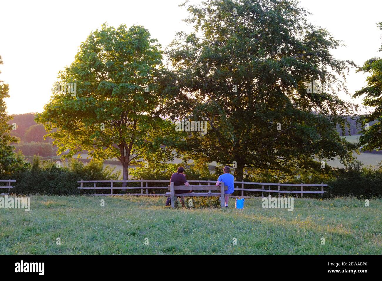 Stone /Royaume-Uni - Mai 31 2020: Social distance en place. Deux personnes assises sur le banc dans un parc et gardant la distance l'une par rapport à l'autre. Banque D'Images