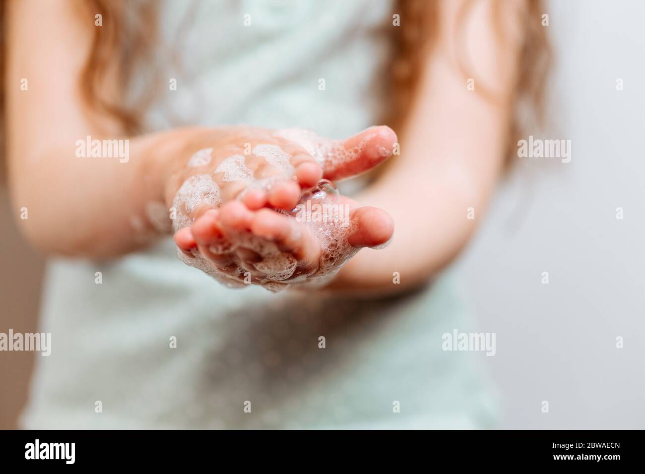 Mains d'enfants dans de la mousse savonneuse. Protection de la santé pendant l'éclosion du virus de la grippe, les épidémies et les maladies infectieuses Banque D'Images