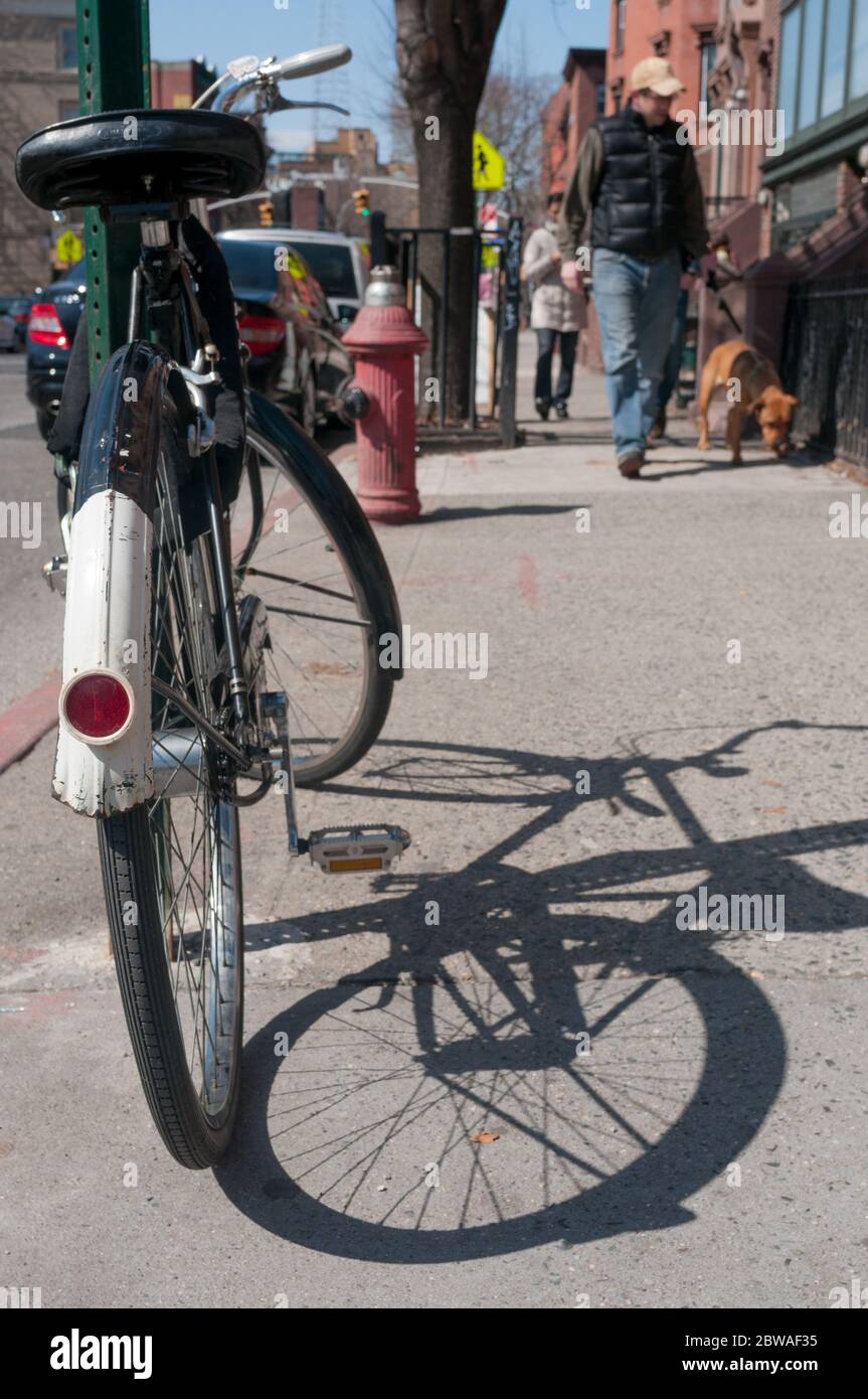 Vélo verrouillé au poteau sur le trottoir, Brooklyn, New York, États-Unis Banque D'Images