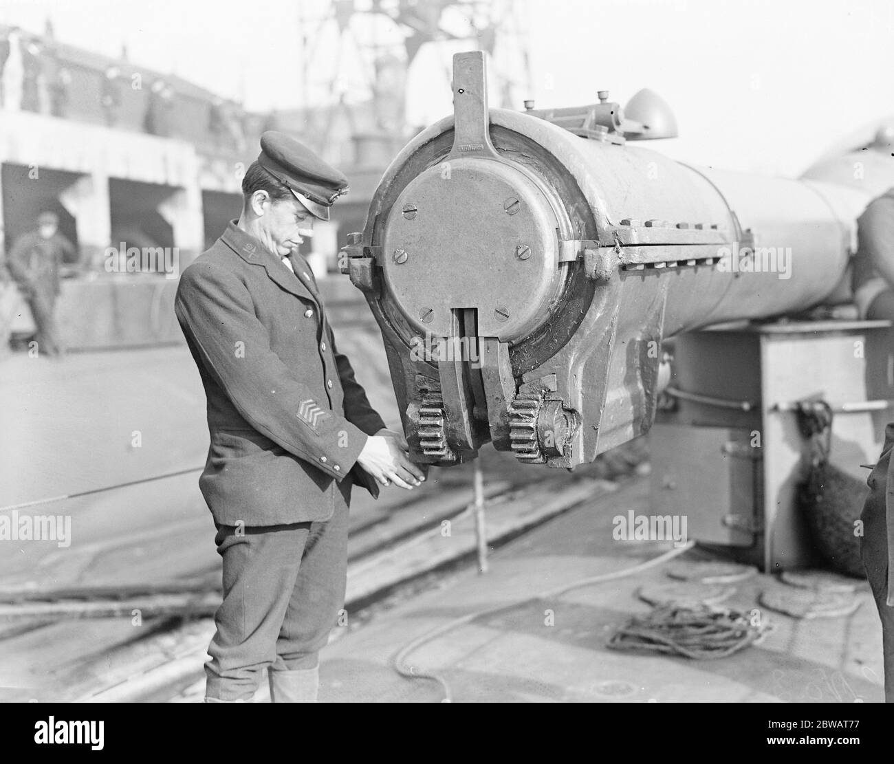 HMS sous-marin n° 3 un des membres de l'équipage inspectant le bouchon étanche à l'eau hydraulique qui s'adapte sur le museau du canon pendant la vaporisation ou la plongée 30 mars 1920 Banque D'Images