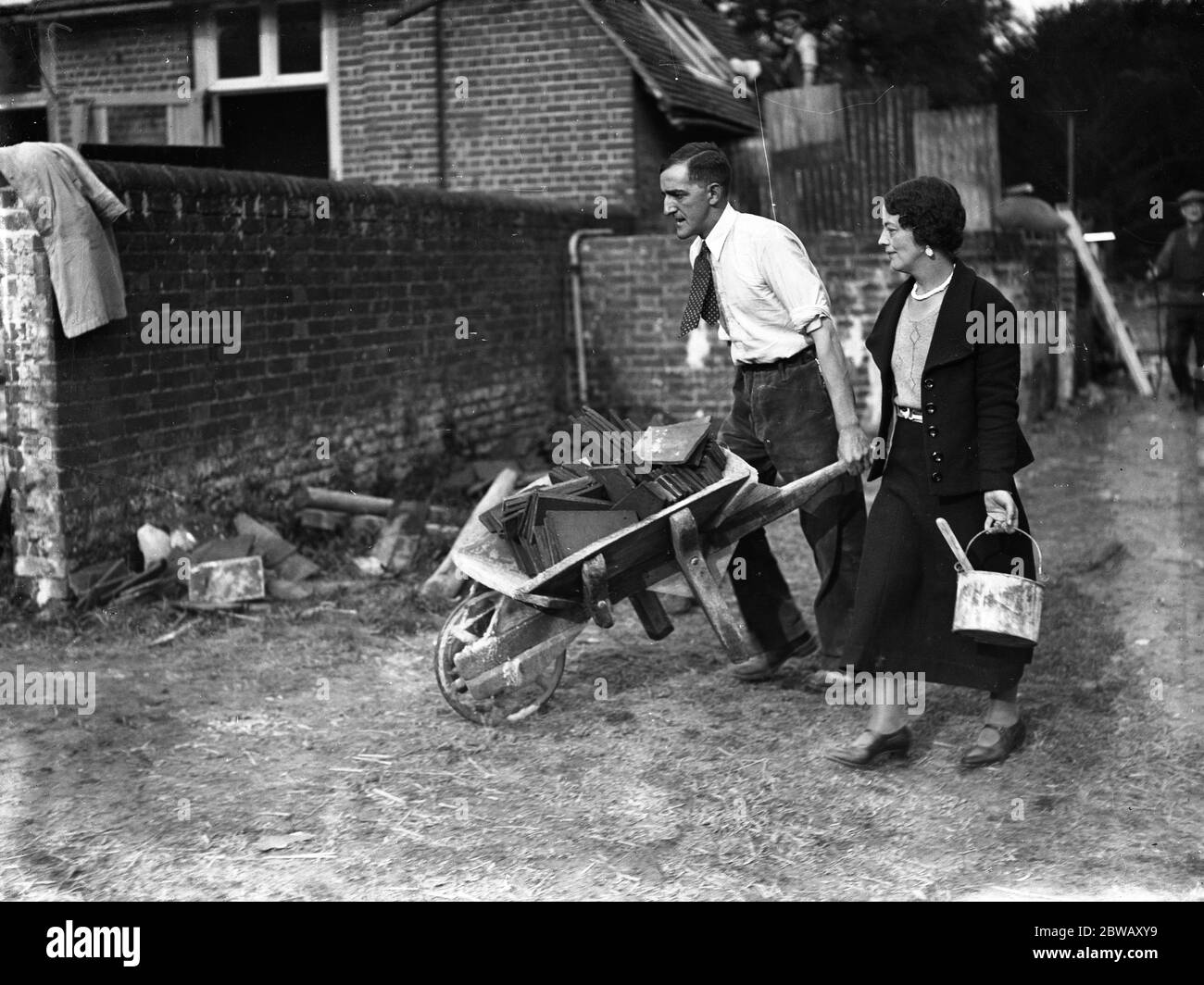 M. A H Gerrard , le sculpteur , et sa fiancée , Mlle Kathleen Leigh Pemberton , au travail de conversion des fours à houblon et des produits laitiers de la maison Leyswood , de Groombridge , de East Sussex , pour leur future maison . 23 octobre 1933 Banque D'Images