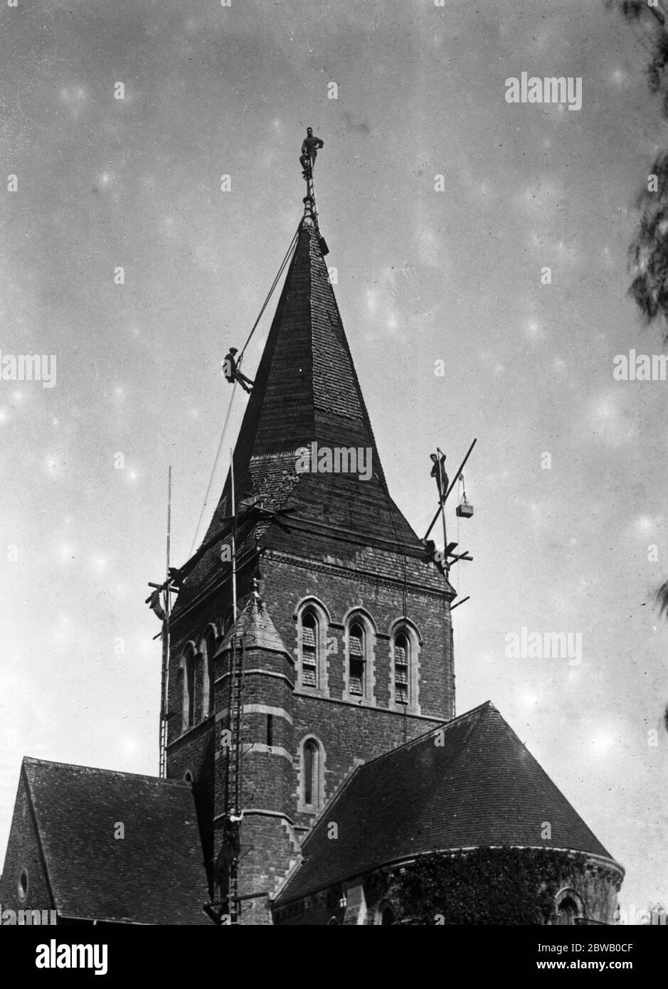 Steeplejacks attaqué sur la flèche de l'église Shackleford , près d'Aldershot , par des fourmis rouges . 25 août 1922 Banque D'Images