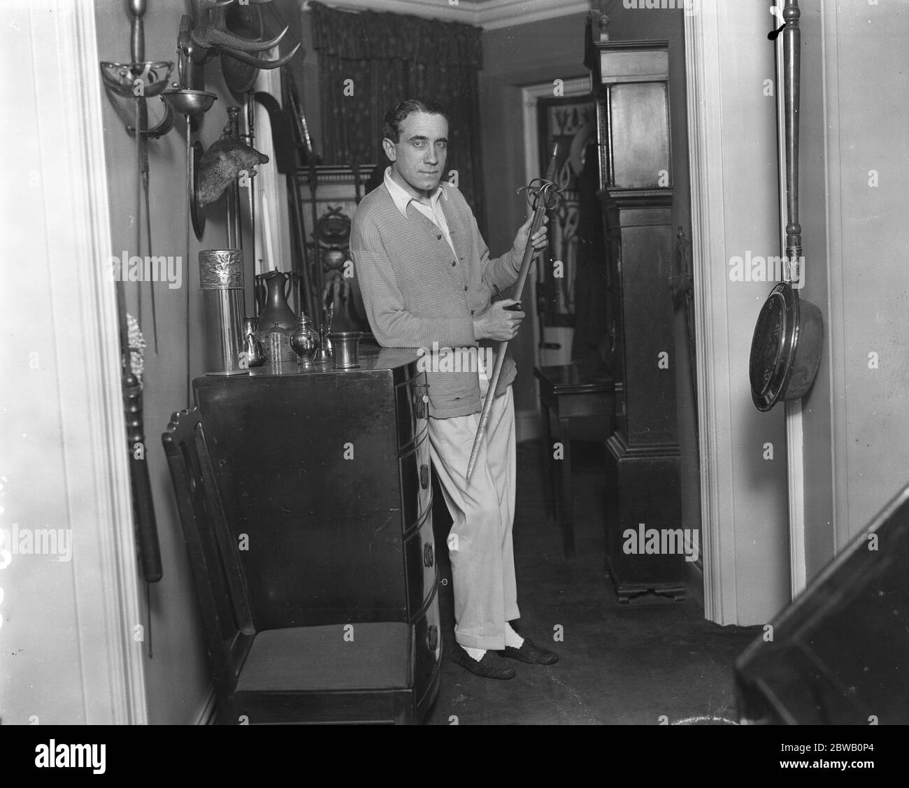 M. Gerald Ames , l' acteur , avec la fierté de sa collection d' épée , un ancien type de ' rappeur ' inscrit ' Menes Pearns ' . Pearns était un fabricant d'épée qui est mort en 1503 . Il est venu de Suède et aurait été utilisé dans les guerres de Gustavus Adolphus Banque D'Images