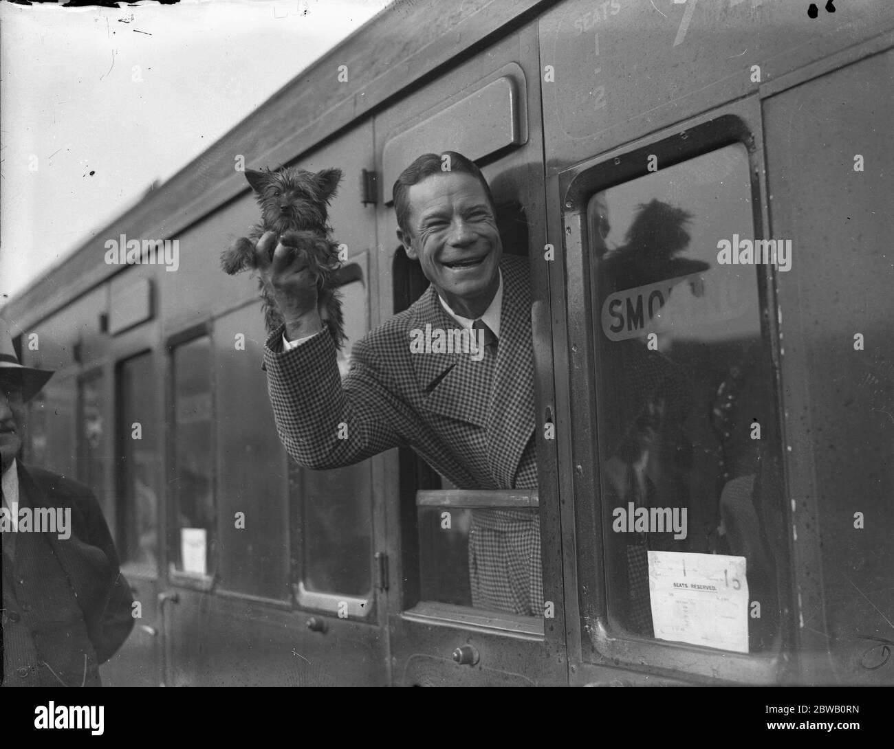 À la gare de Waterloo , à son retour aux États-Unis , l' acteur américain , Joe E Brown , avec son petit chien . 1936 Banque D'Images