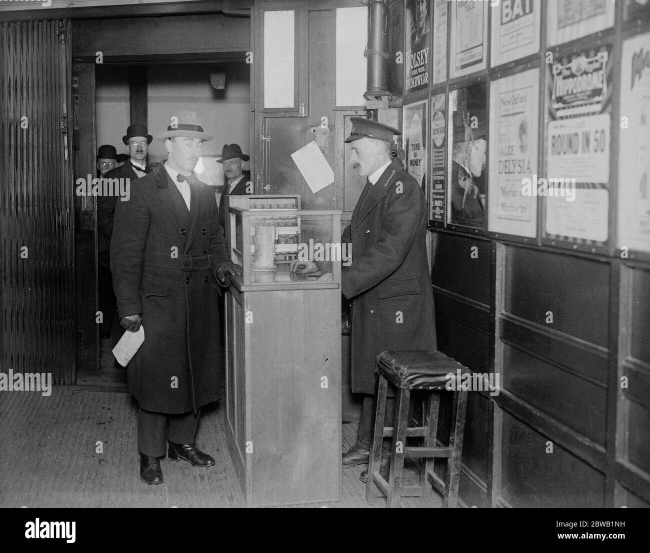 Liftman , le collecteur de billets et le commis de réservation tout en un . Une nouvelle machine à commande électrique a été installée à l'intérieur de l'ascenseur, dans le métro à la station Aldwych . Il permet à l'ascenseur d'émettre et de récupérer des billets et en même temps de contrôler le fonctionnement de son ascenseur . Le monte-charge qui émet un billet depuis la machine . 5 mai 1922 Banque D'Images