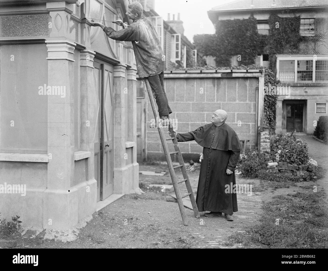 La prouesse de construction de Monk . Salle et partie de l'église érigée par lui-même à Hayes dans Middlesex . Frère Raymond , le monk constructeur , est vu sur l'échelle . 1er septembre 1922 Banque D'Images