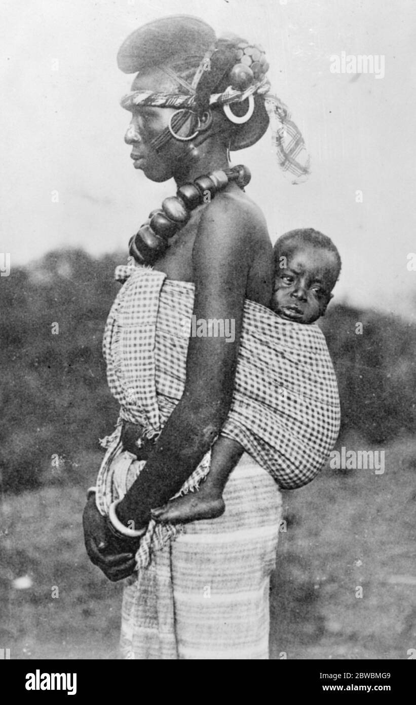 Une dame de la société intelligente en Guinée française avec son bébé sur le dos . Elle appartient à la tribu Malinke et porte la coiffure caractéristique de Foulah . 8 décembre 1922 Banque D'Images