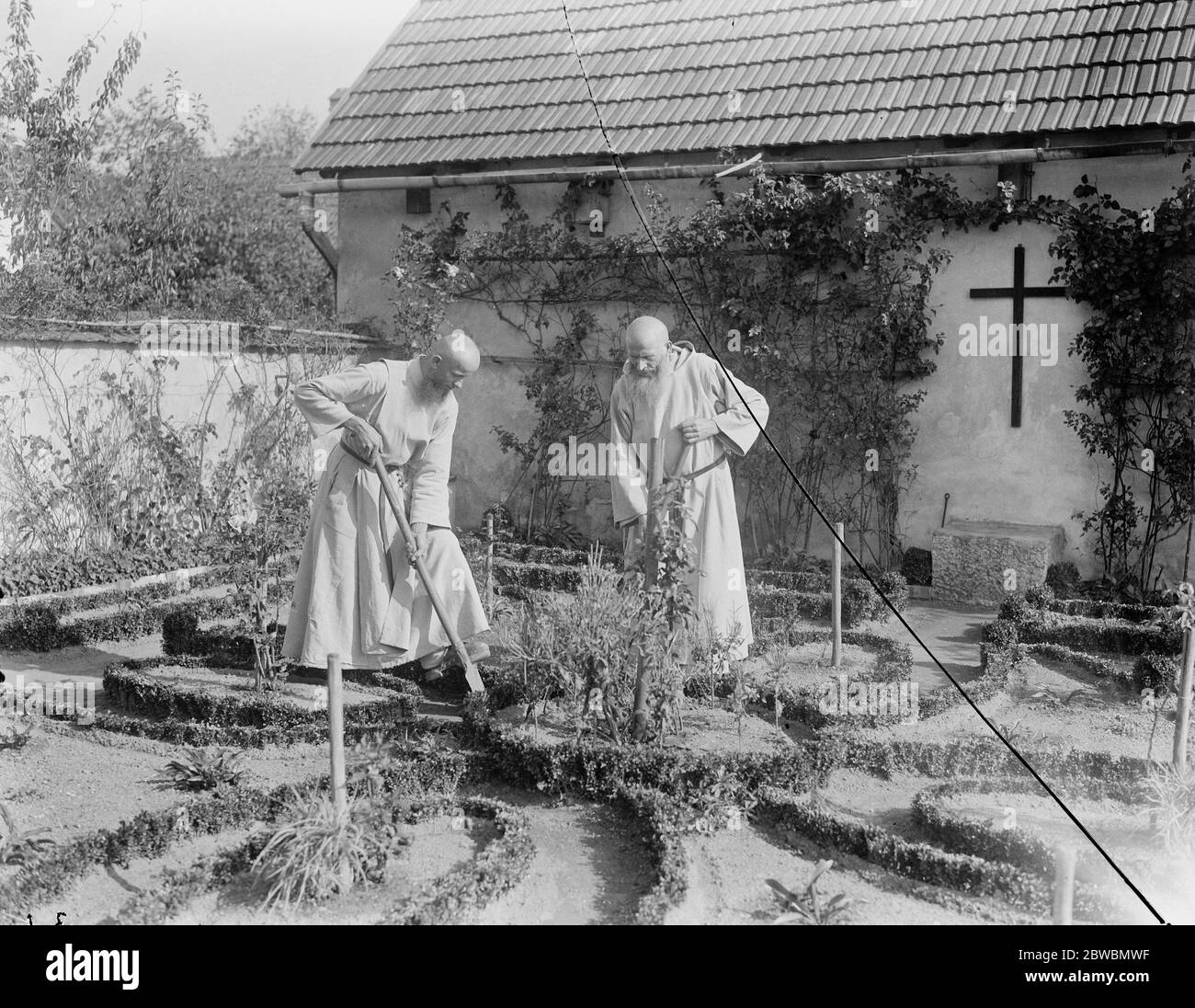 Moines occupés dans leur jardin au monastère des Camaldes qui se dresse sur un sommet de montagne surplombant Cracovie , Pologne , fondée au XVIIe siècle . 24 octobre 1921 Banque D'Images