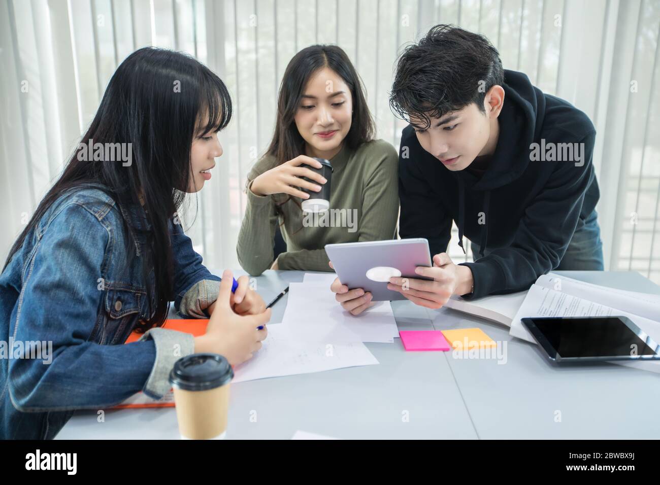 Les étudiants asiatiques lisent des livres et utilisent des tablettes numériques pour trouver des informations pour le travail et les études en ligne Banque D'Images