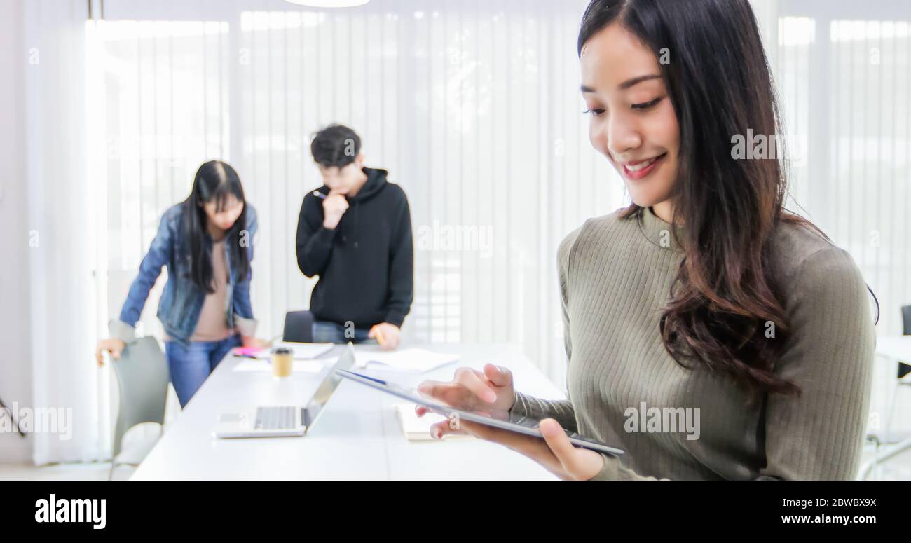 Les étudiantes asiatiques utilisent des tablettes numériques pour trouver des informations sur leur travail et leurs études en ligne. Banque D'Images