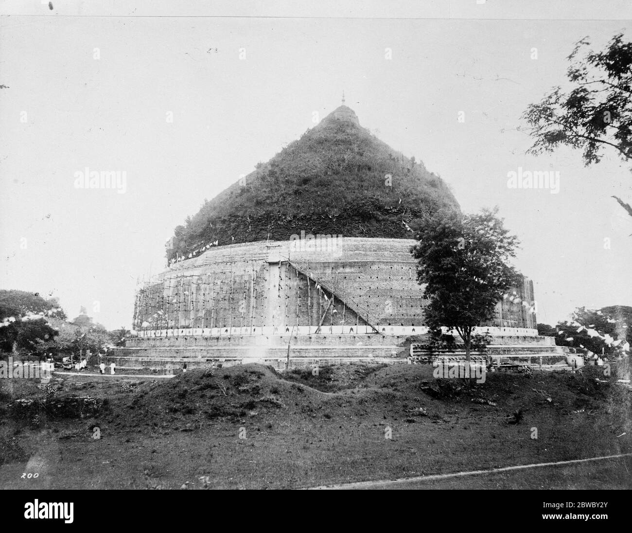 Les St Pauls de Ceylan . La célèbre Ruanweli , ou Pagode de poussière d'or , à Anuradhapura , qui, au cours des 2,000 années a été en mauvaise réparation , et est maintenant fiévement travaillé par les autochtones . Plus vieux que St Paul, pour la pagode de poussière d'or a été établie au deuxième siècle avant Jésus-Christ par le plus grand des rois bouddhistes de Ceylan , la Pagode ressemble à une colline conique , entouré par un mur et surmonté d'une petite flèche . C'est cependant , en réalité , presque une masse solide de briqueteries de 270 pi de circonférence . 7 février 1925 Banque D'Images