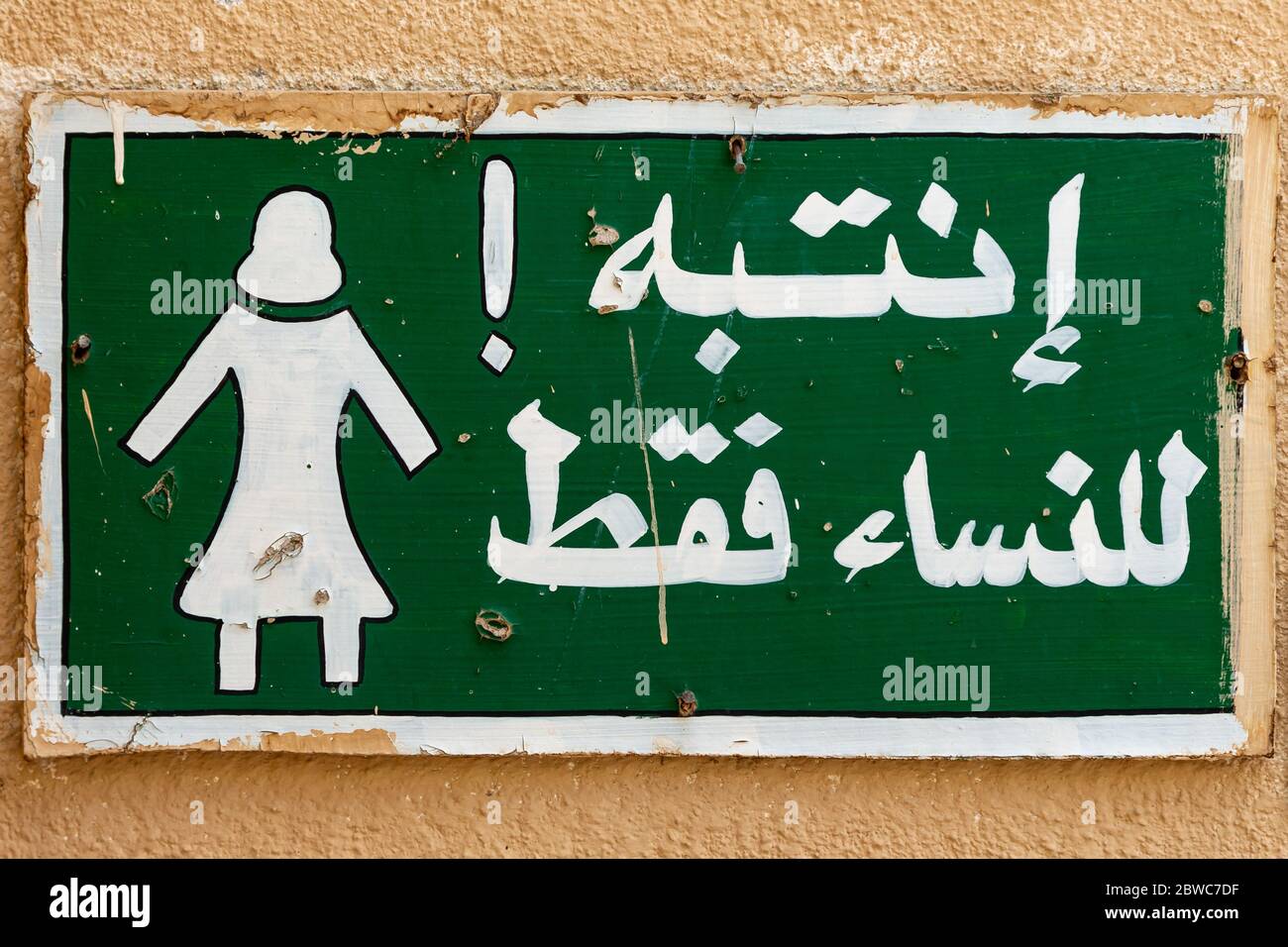Panneau sur un mur dans la vieille ville d'Al Mudairib en Oman permettant l'entrée pour les femmes seulement Banque D'Images