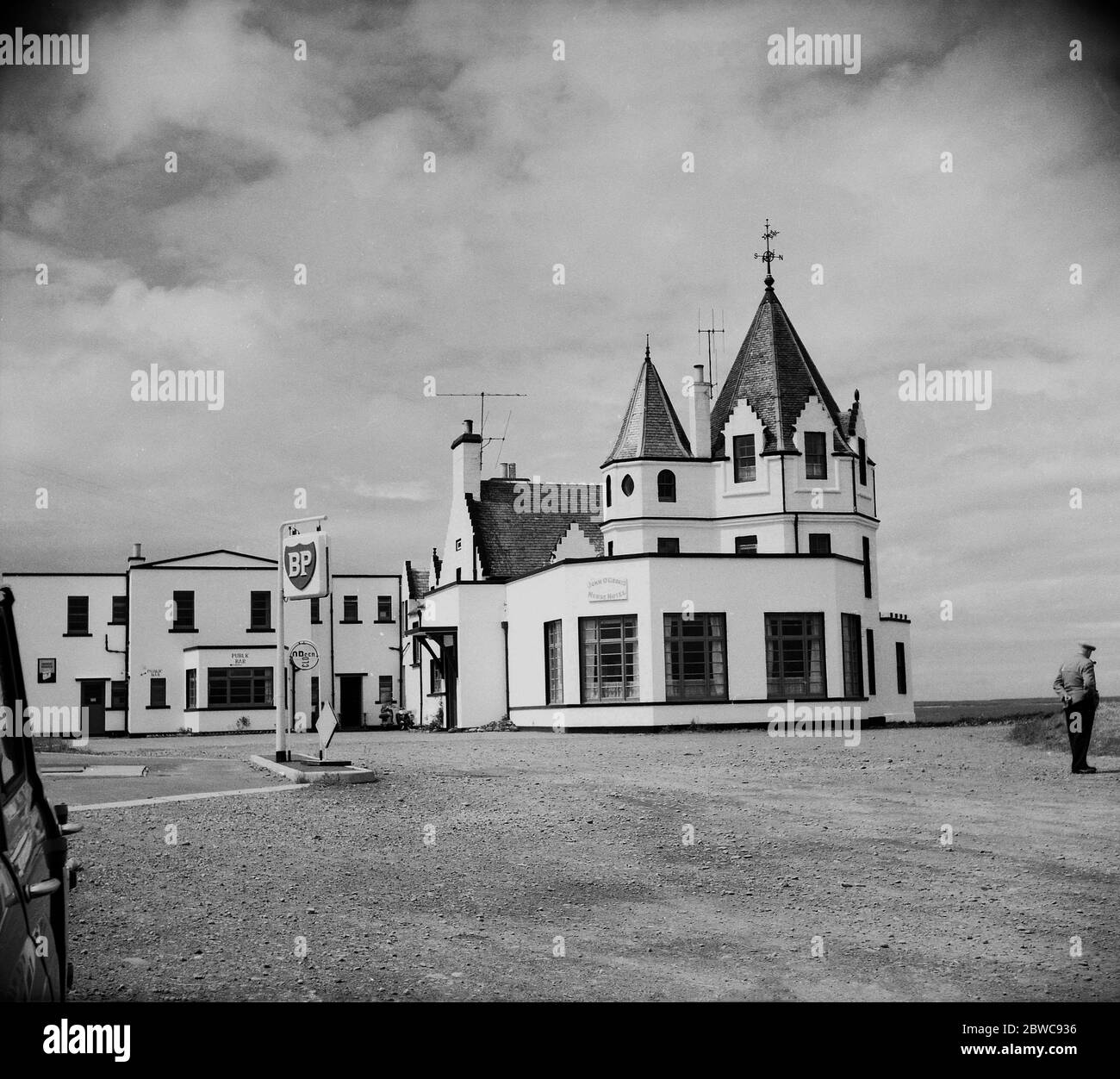 Années 1950, vue historique, extérieure de l'hôtel John o'Groats House, Canisbay, Caithness, Écosse, Royaume-Uni, montrant la forme distinctive du bâtiment, Tourelles et parking couvert de gravier avec sa propre station de remplissage de carburant.la maison emblématique de style octogonal a été construite en 1875 près ou sur le site de la maison de Dutchman Jan de Groot dont le site prend son nom, Qui, dans le passé, a couru un ferry à l'île d'Orkney en faisant payer une pièce qui est devenue connue sous le nom de "l'aine". Banque D'Images