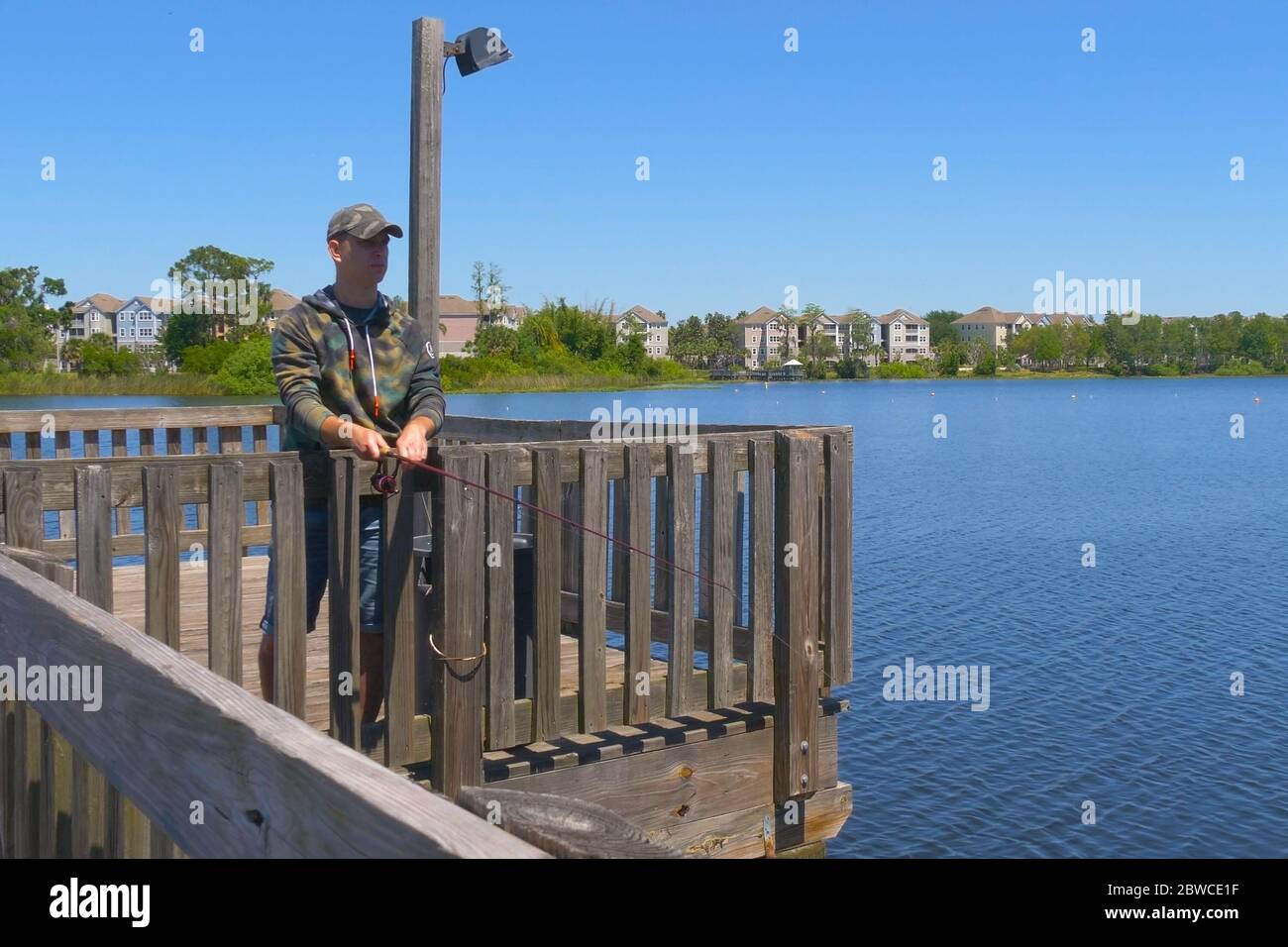 Homme pêche et tient la canne à pêche. Banque D'Images