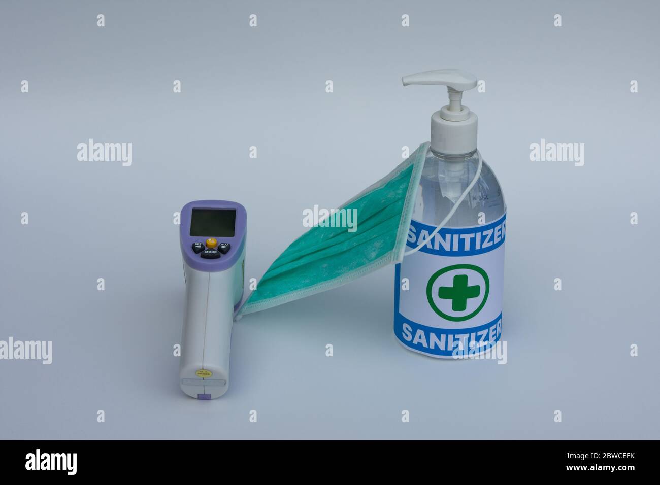 Thermomètre infrarouge, masque chirurgical et gel désinfectant pour les mains. Concept de protection contre les pandémies de coronavirus. Banque D'Images