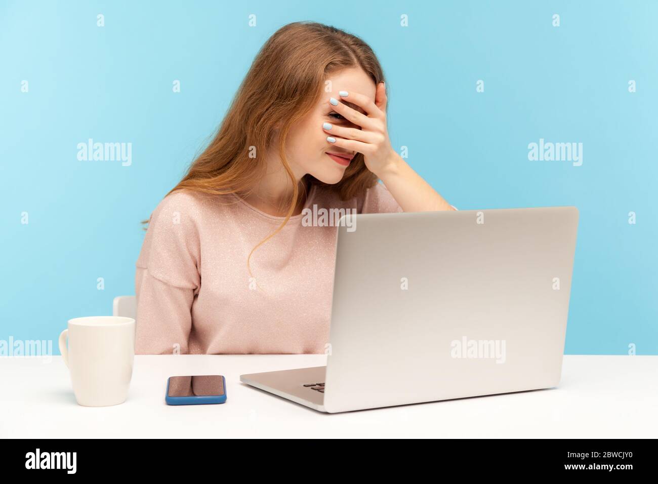Curieuse femme curieux employé regardant à travers les doigts à l'écran d'ordinateur portable, se sentant peur et honte de regarder le contenu Web secret sur Internet, parlant Banque D'Images