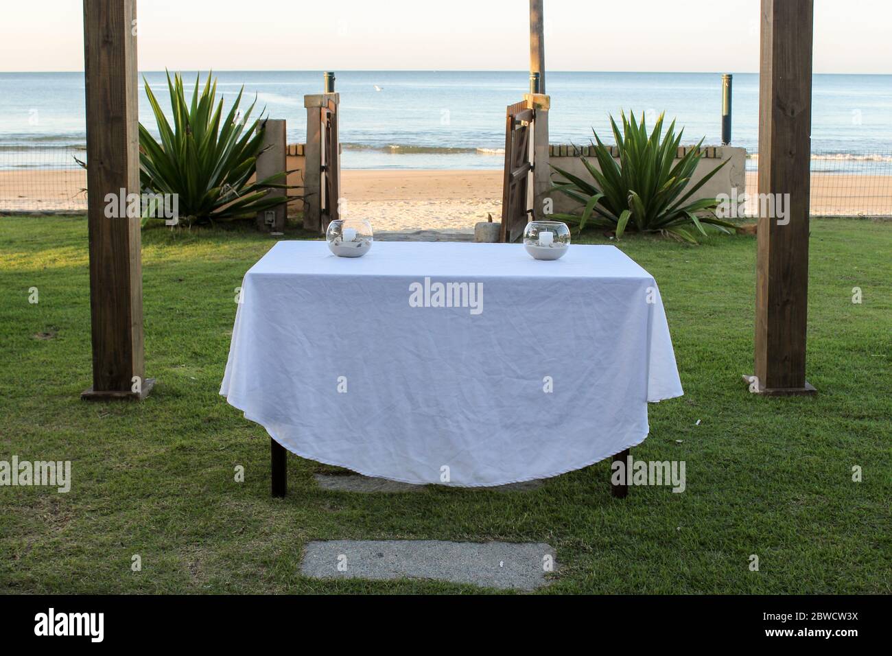 Au centre de l'image, nous avons une table avec deux pièces centrales qui fonctionneront comme un autel à quelques mètres de la côte sablonneuse et de la mer bleue. Banque D'Images