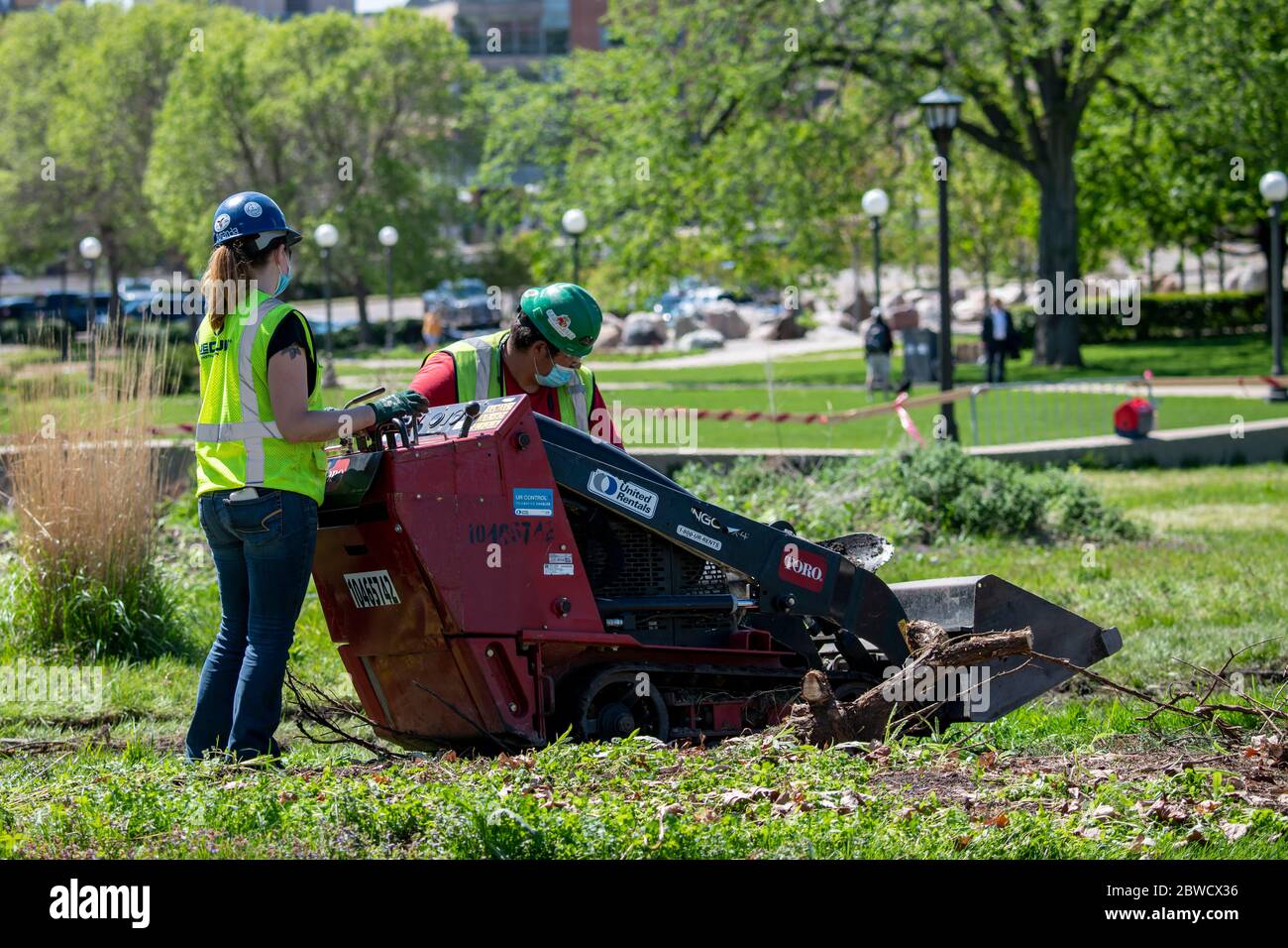 St. Paul, Minnesota. Les ouvriers du bâtiment portant des masques pour se protéger du coronavirus retravaillent le paysage sur le terrain du capitole. Banque D'Images