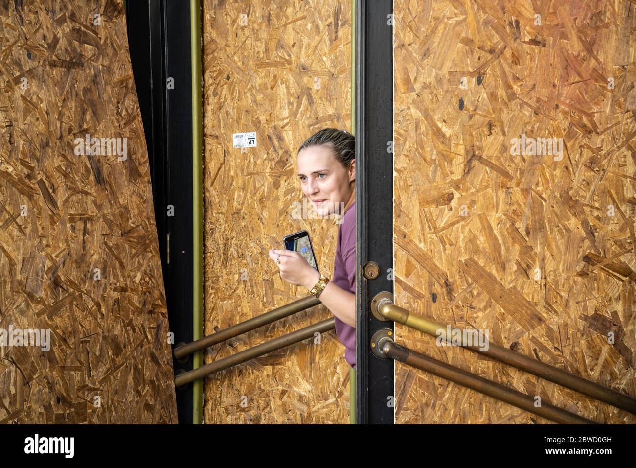 Charleston, États-Unis. 31 mai 2020. Un propriétaire de magasin regarde depuis le front de vente embarqué le long du quartier commerçant de King Street après une manifestation sur la mort de George Floyd, devenu violent et destructeur le 31 mai 2020 à Charleston, Caroline du Sud. Floyd a été étouffé par la police à Minneapolis, ce qui a entraîné des manifestations qui ont balayé le pays. Crédit : Richard Ellis/Alay Live News Banque D'Images