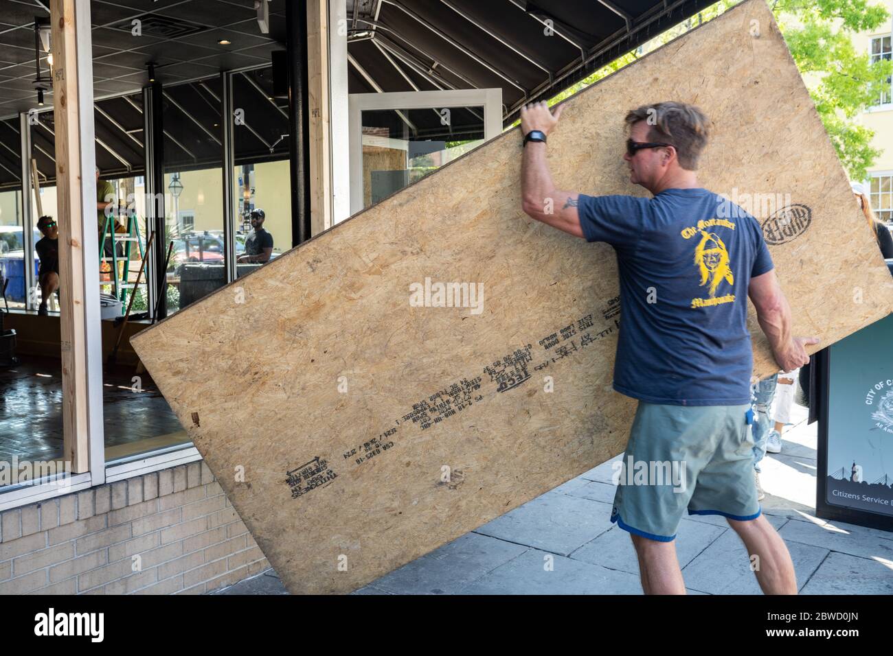 Charleston, États-Unis. 31 mai 2020. Des volontaires aident à remplacer les fenêtres brisées par des panneaux de contreplaqué dans un restaurant le long du quartier commerçant de King Street après une manifestation sur la mort de George Floyd, devenu violent et destructeur le 31 mai 2020 à Charleston, Caroline du Sud. Floyd a été étouffé par la police à Minneapolis, ce qui a entraîné des manifestations qui ont balayé le pays. Crédit : Richard Ellis/Alay Live News Banque D'Images