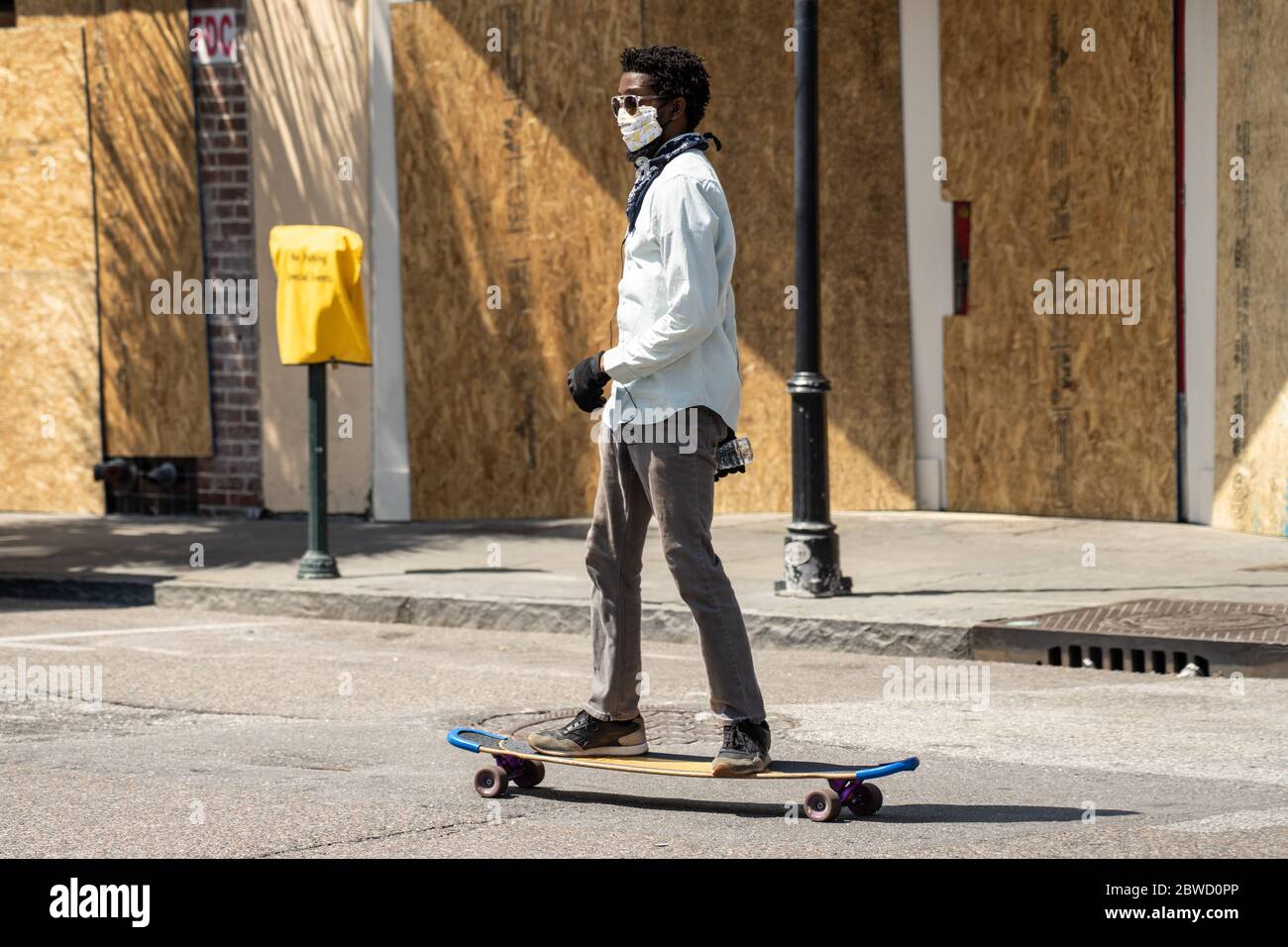 Charleston, États-Unis. 31 mai 2020. Un skateboard passe devant les boutiques à bord le long du quartier commerçant de King Street après une manifestation sur la mort de George Floyd, devenu violent et destructeur le 31 mai 2020 à Charleston, Caroline du Sud. Floyd a été étouffé par la police à Minneapolis, ce qui a entraîné des manifestations qui ont balayé le pays. Crédit : Richard Ellis/Alay Live News Banque D'Images