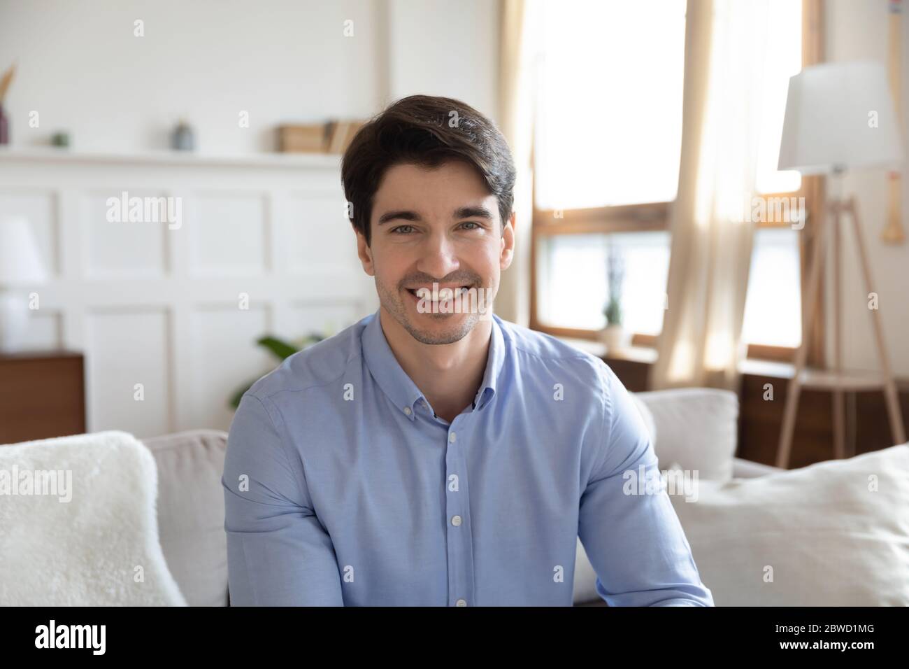 Portrait d'un jeune homme souriant en conversation vidéo Banque D'Images