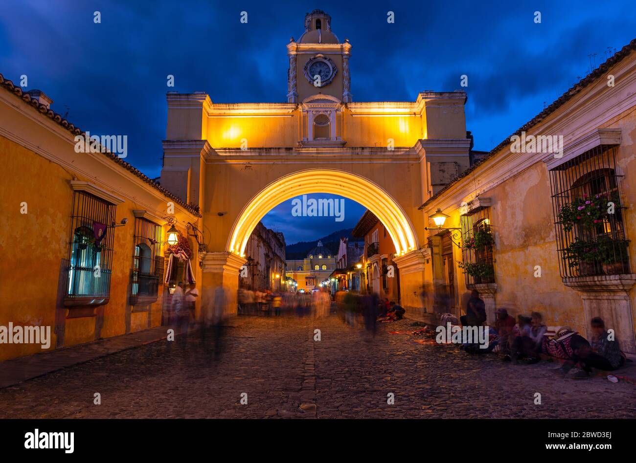 Exposition longue la nuit avec flou de mouvement des gens par l'Arc de Santa Catalina, Antigua, Guatemala. Banque D'Images