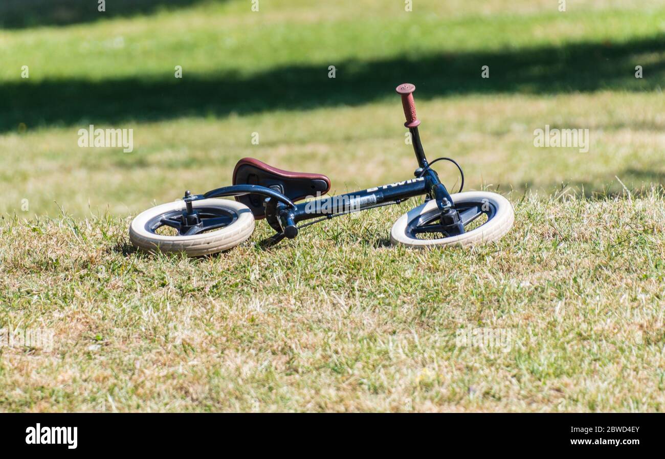 Vélo d'équilibre pour les enfants allongé sur l'herbe dans le parc Banque D'Images