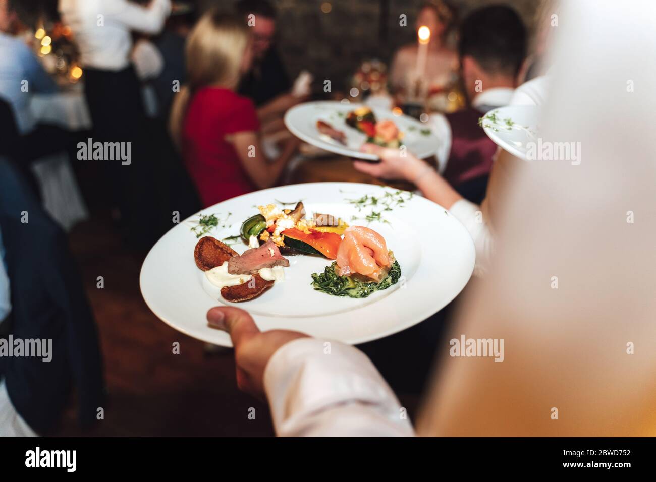 Homme tenant une assiette blanche avec de la nourriture a obtenu de la table de buffet en libre-service. Concept de célébration, fête, anniversaire ou mariage. Banque D'Images
