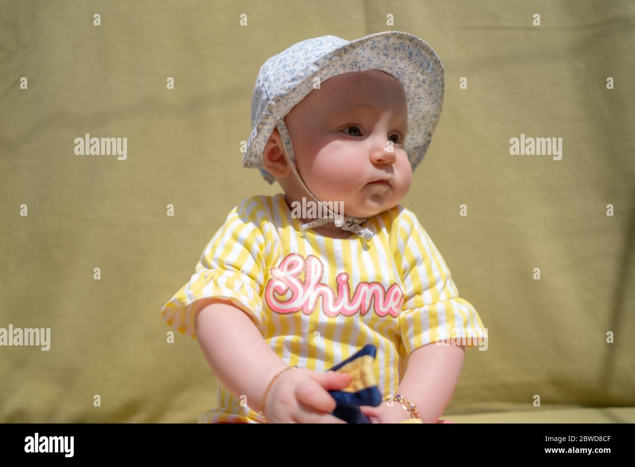 Mignon bébé fille porter adorable chapeau regardant l'appareil photo faire des visages drôles sur fond vert Banque D'Images