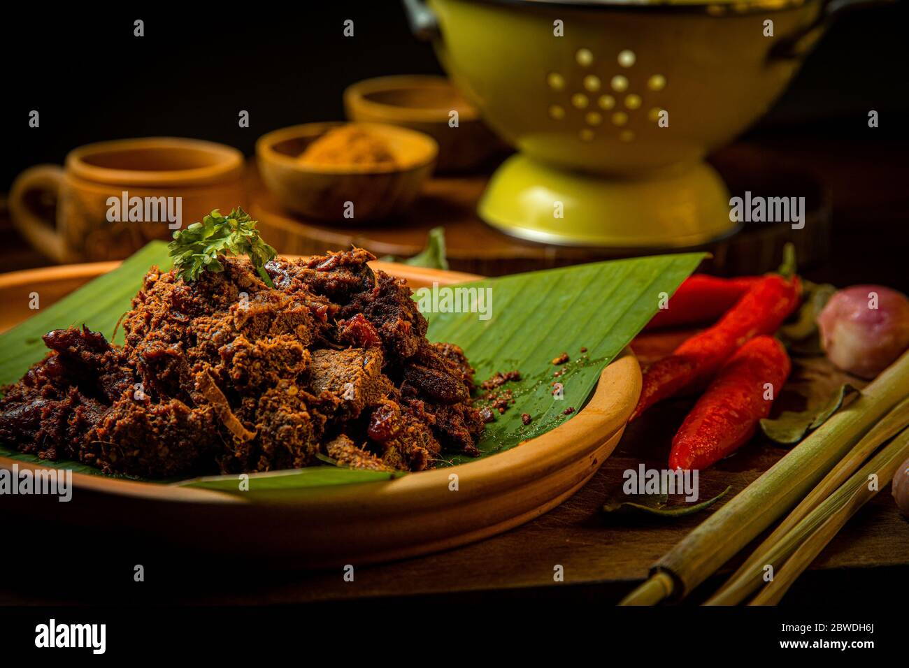 Rendang Daging SAPI ou bœuf ragoût de la nourriture traditionnelle de Padang, Indonésie. Le plat est disposé parmi les épices et les herbes utilisées dans la recette originale Banque D'Images Rendang Daging SAPI ou bœuf ragoût de la nourriture traditionnelle de Padang, Indonésie. Le plat est disposé parmi les épices et les herbes utilisées dans la recette originale Banque D'Images