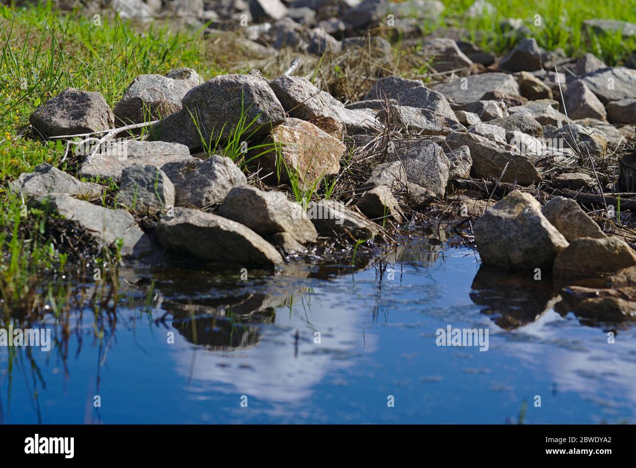 Des piles de pierres et de galets près de l'eau bleue par beau temps Banque D'Images