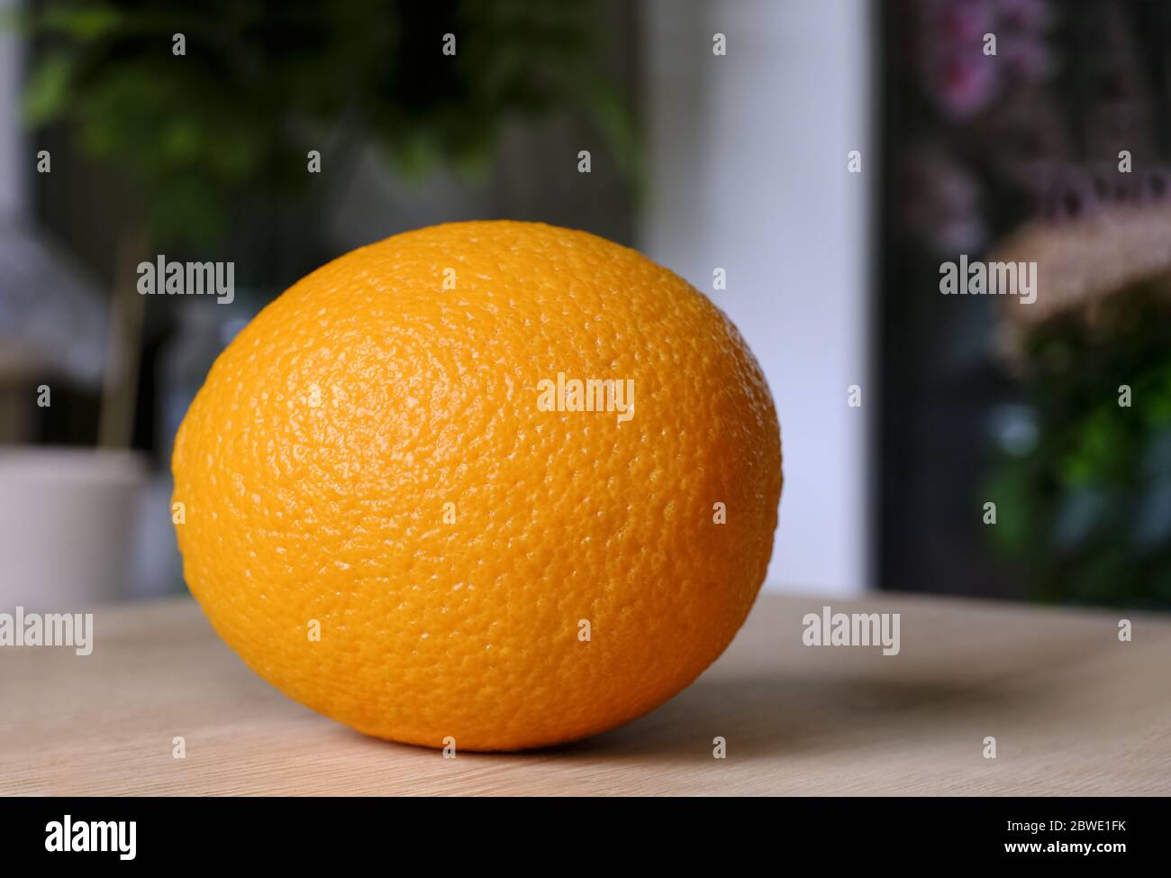 Une orange fraîche et lumineuse savoureuse sur une table en bois, nourriture végétalienne naturelle.gros plan. Zeste d'orange. Vente, publicité. Banque D'Images