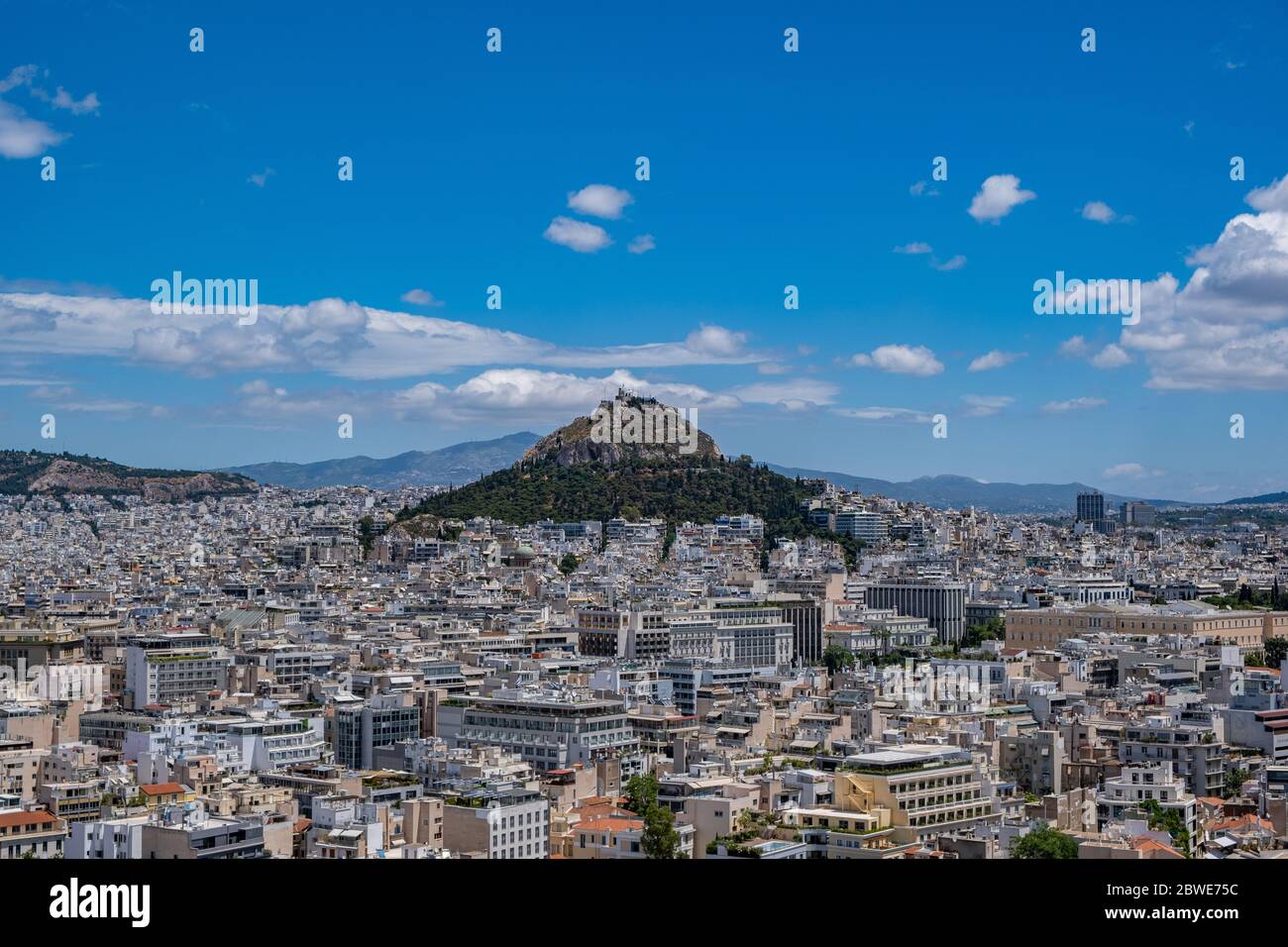 Photo aérienne du mont Lycabette et du paysage urbain d'Athènes, vue depuis la colline de l'Acropole en Grèce. Ciel bleu avec nuages, jour de printemps ensoleillé. Banque D'Images