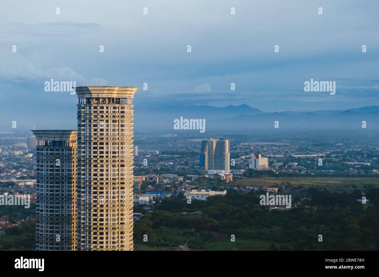 Un bâtiment en vue avec un fond de montagne couvert de smog dans la zone métropolitaine de Karawaci, Tangerang. Banque D'Images