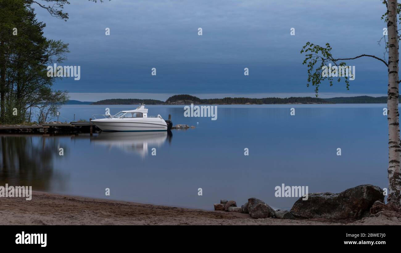 Crépuscule d'été avec bateau à moteur sur le lac Päijänne en Finlande Banque D'Images