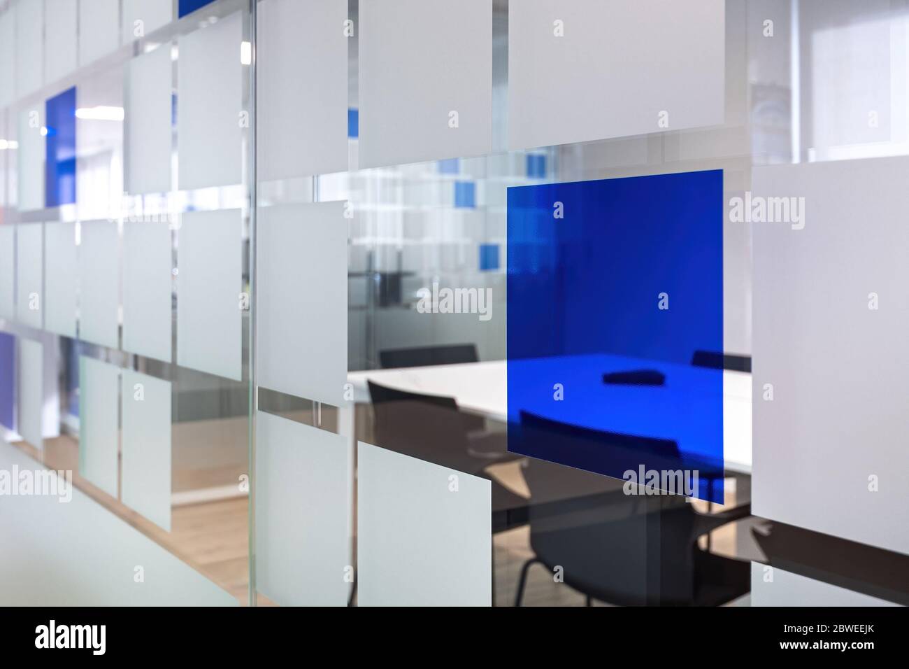 Un mur de verre sépare les pièces du bureau. Salle de conversation vide avec table et chaises dans un intérieur de bureau moderne. Banque D'Images