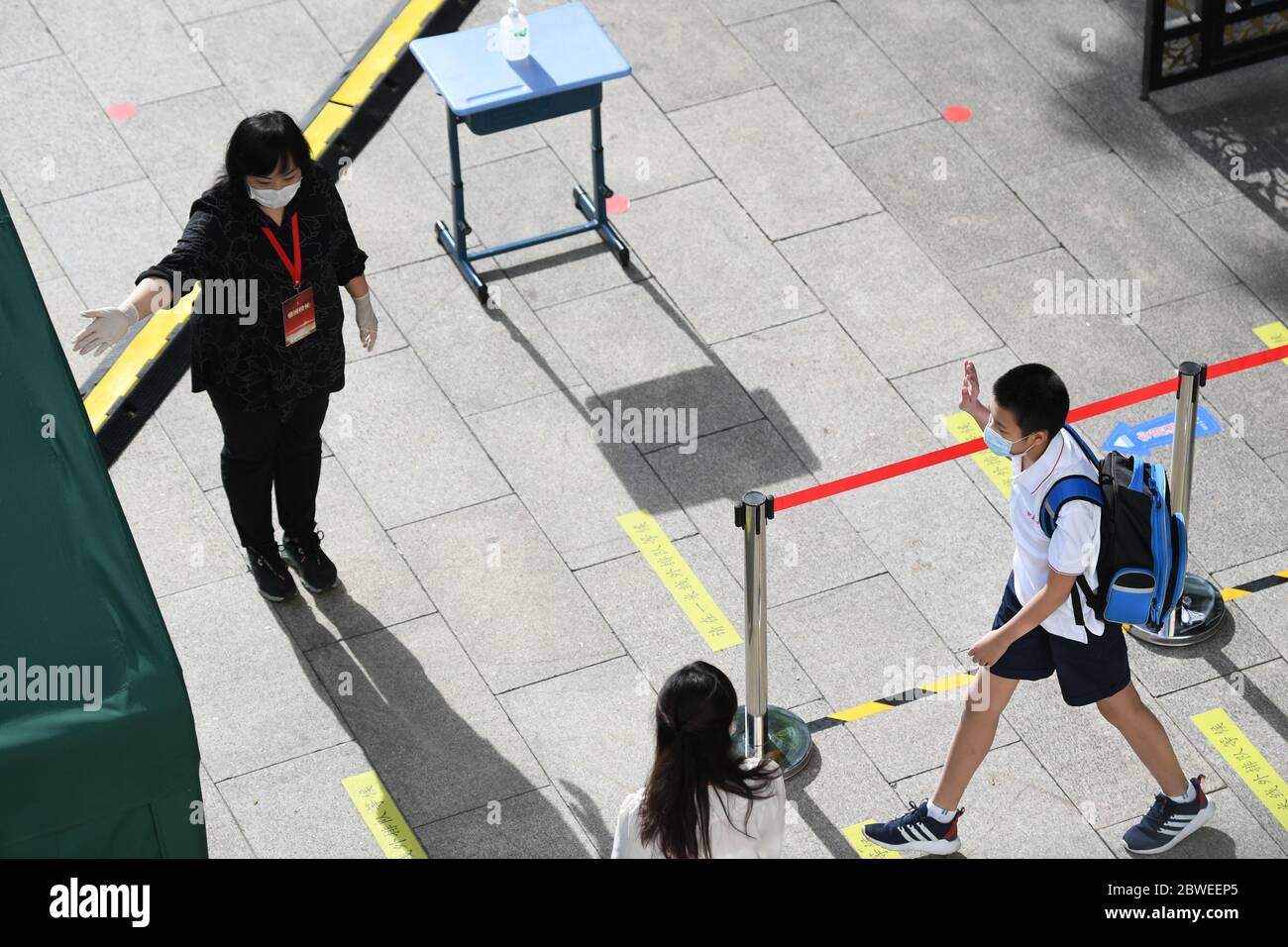 Pékin, Chine. 1er juin 2020. Un étudiant accueille un enseignant lorsqu'il entre à l'école de Beijing, capitale de la Chine, le 1er juin 2020. Les élèves de première et deuxième années de l'enseignement secondaire, de première et deuxième années de l'enseignement secondaire et de sixième année de l'enseignement primaire sont retournés à l'école pour ce semestre à Beijing lundi. Crédit: JU Huanzong/Xinhua/Alamy Live News Banque D'Images