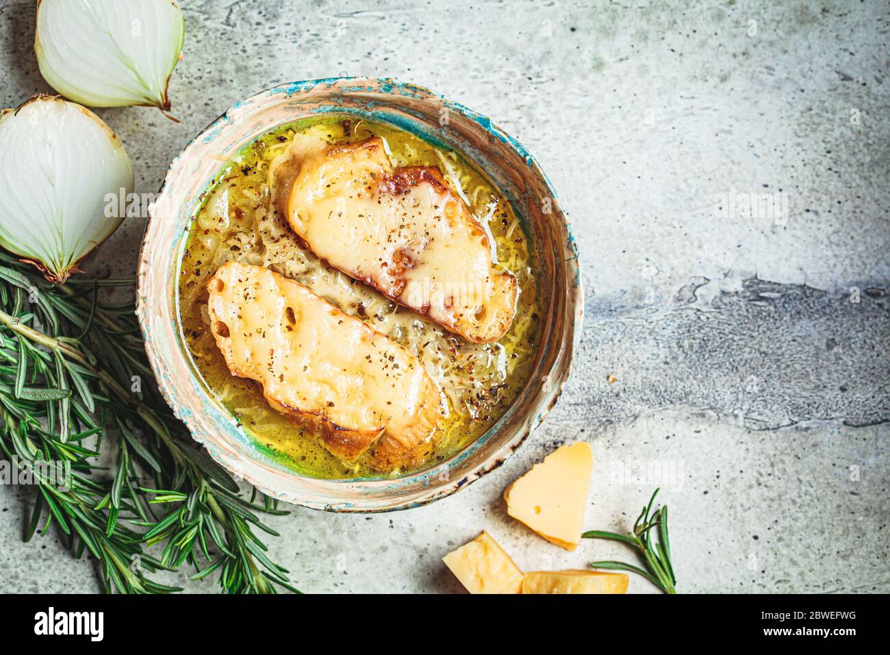 Soupe traditionnelle française à l'oignon avec baguette et fromage dans un bol en céramique. Banque D'Images