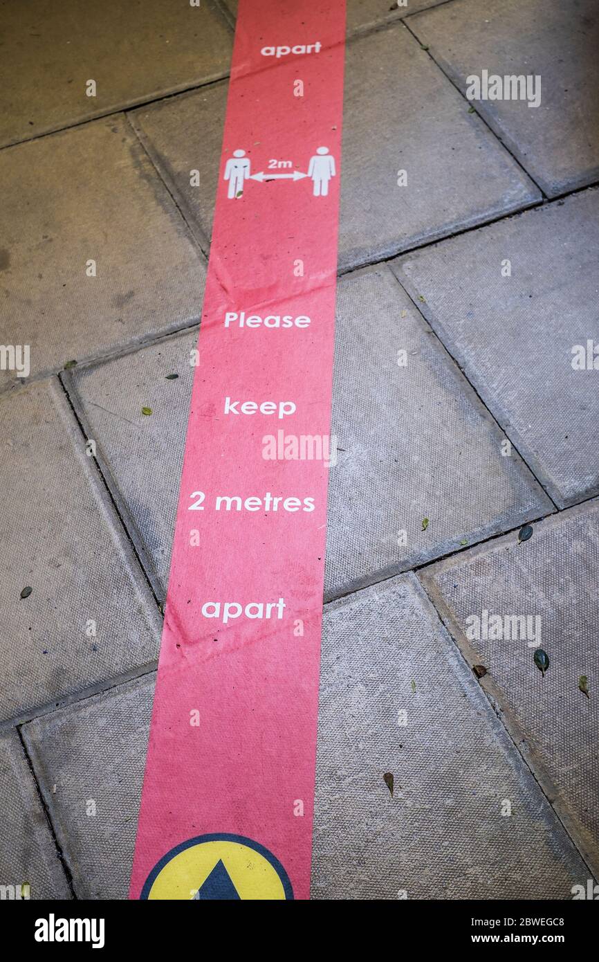Conseils pour la distanciation sociale placée sur le plancher en raison de la pandémie du coronavirus Covid 19. Banque D'Images