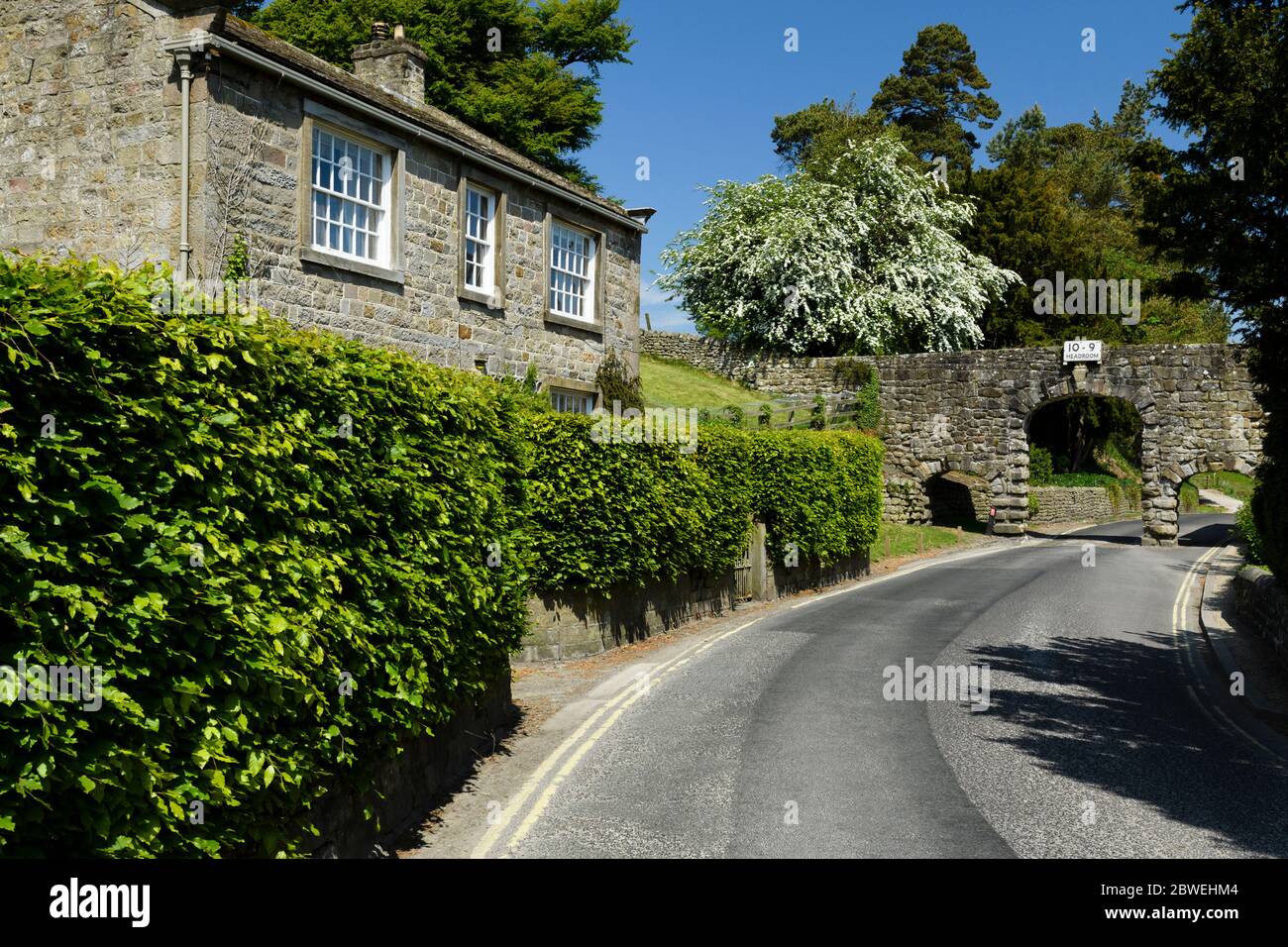 Country Lane, Cottage, arcade en pierre (aqueduc historique, 3 arches, panneau d'avertissement de la tête 10' 9'') - B6160 Bolton Abbey village, Yorkshire, Angleterre, Royaume-Uni Banque D'Images