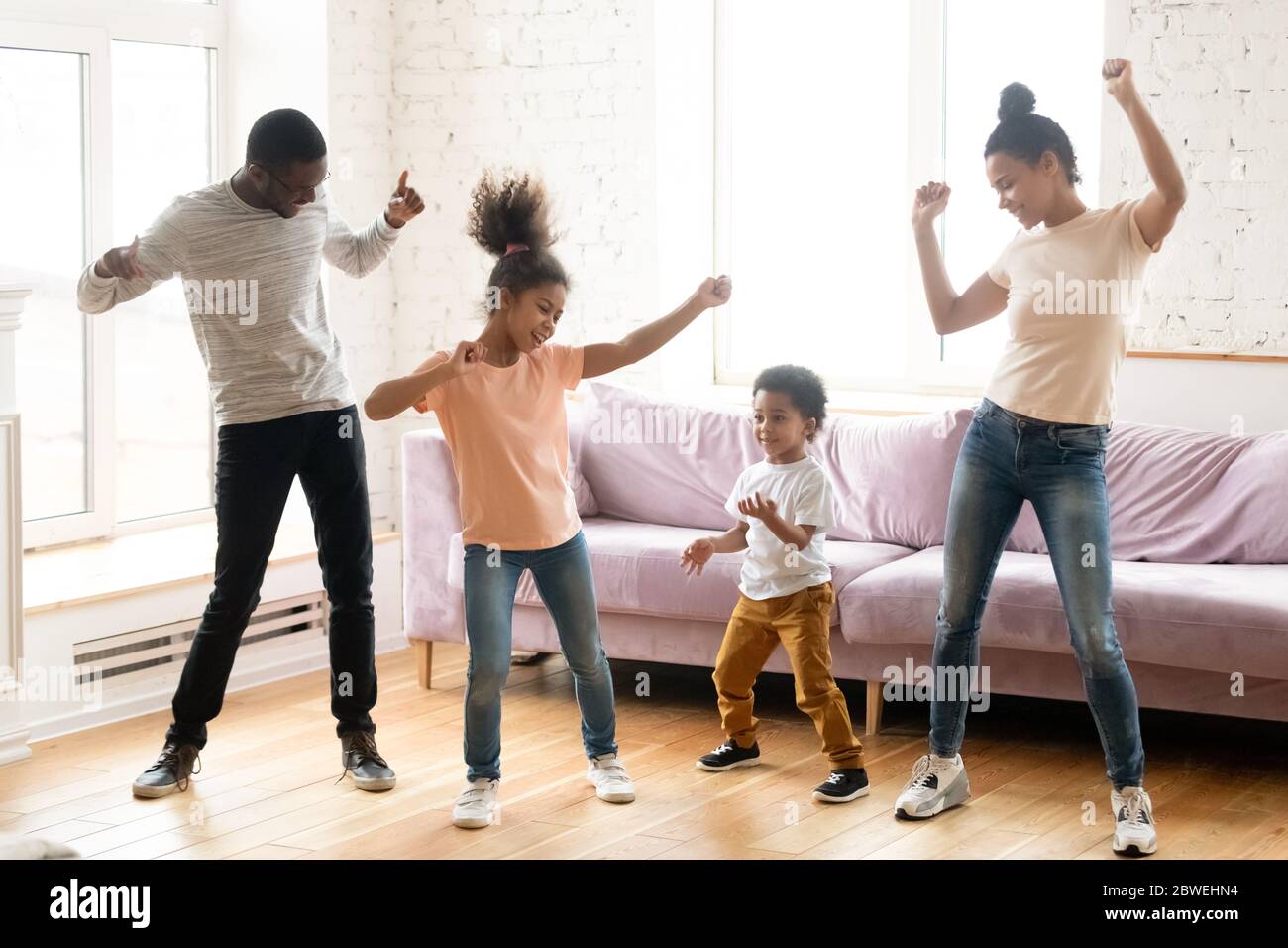 Famille africaine avec enfants dansant dans le salon moderne Banque D'Images