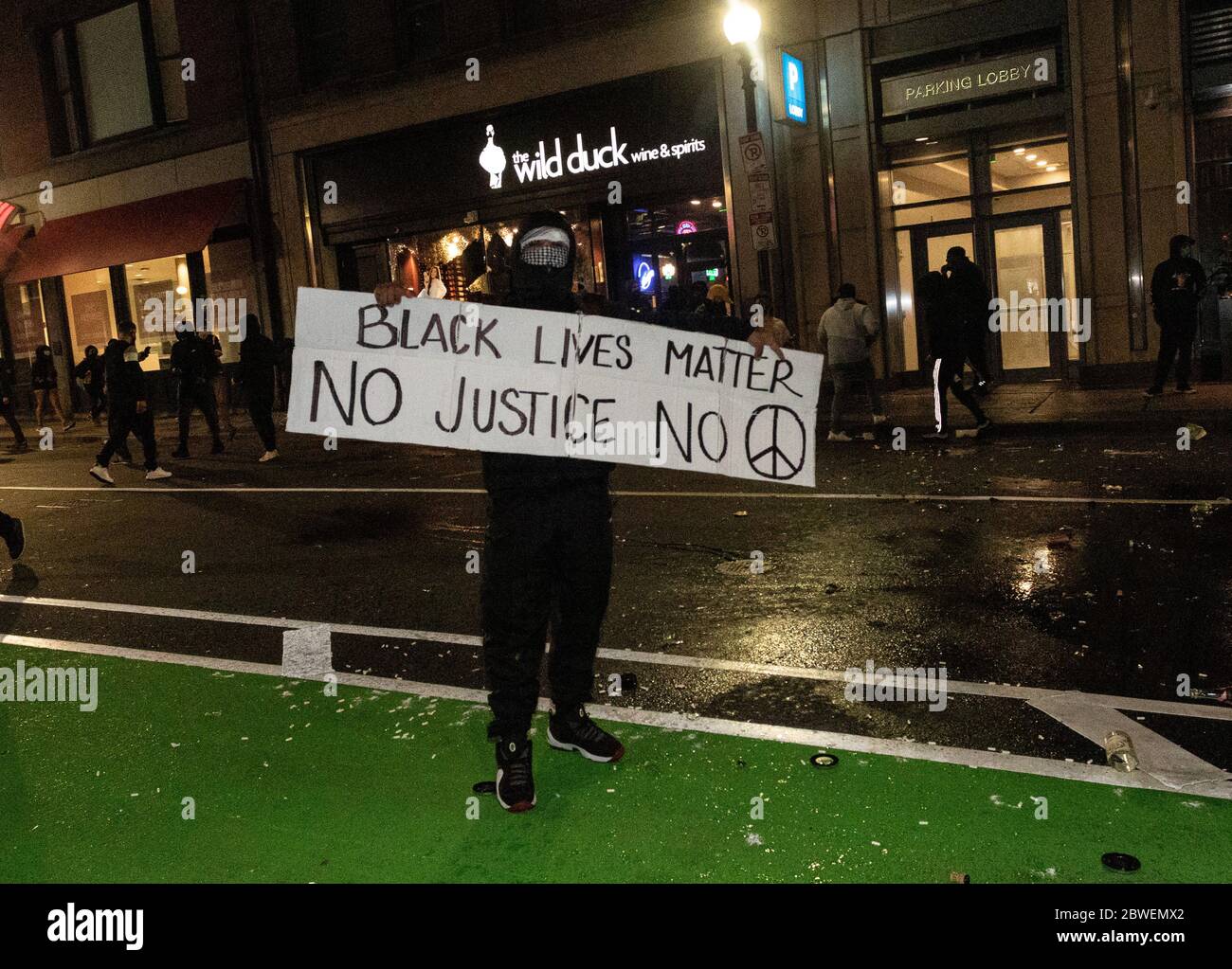 31 mai 2020, Boston, Massachusetts, États-Unis: Un homme portant un panneau "Black Lives Matter No Justice No Peace" à l'extérieur d'un magasin de liqueurs Wild Duck pillé à Boston. De nombreux magasins du centre-ville de Boston ont été pillés à la suite d'un rassemblement contre la mort de George, détenu par la police de Minneapolis, à Boston. Crédit : AFLO Co. Ltd./Alay Live News Banque D'Images