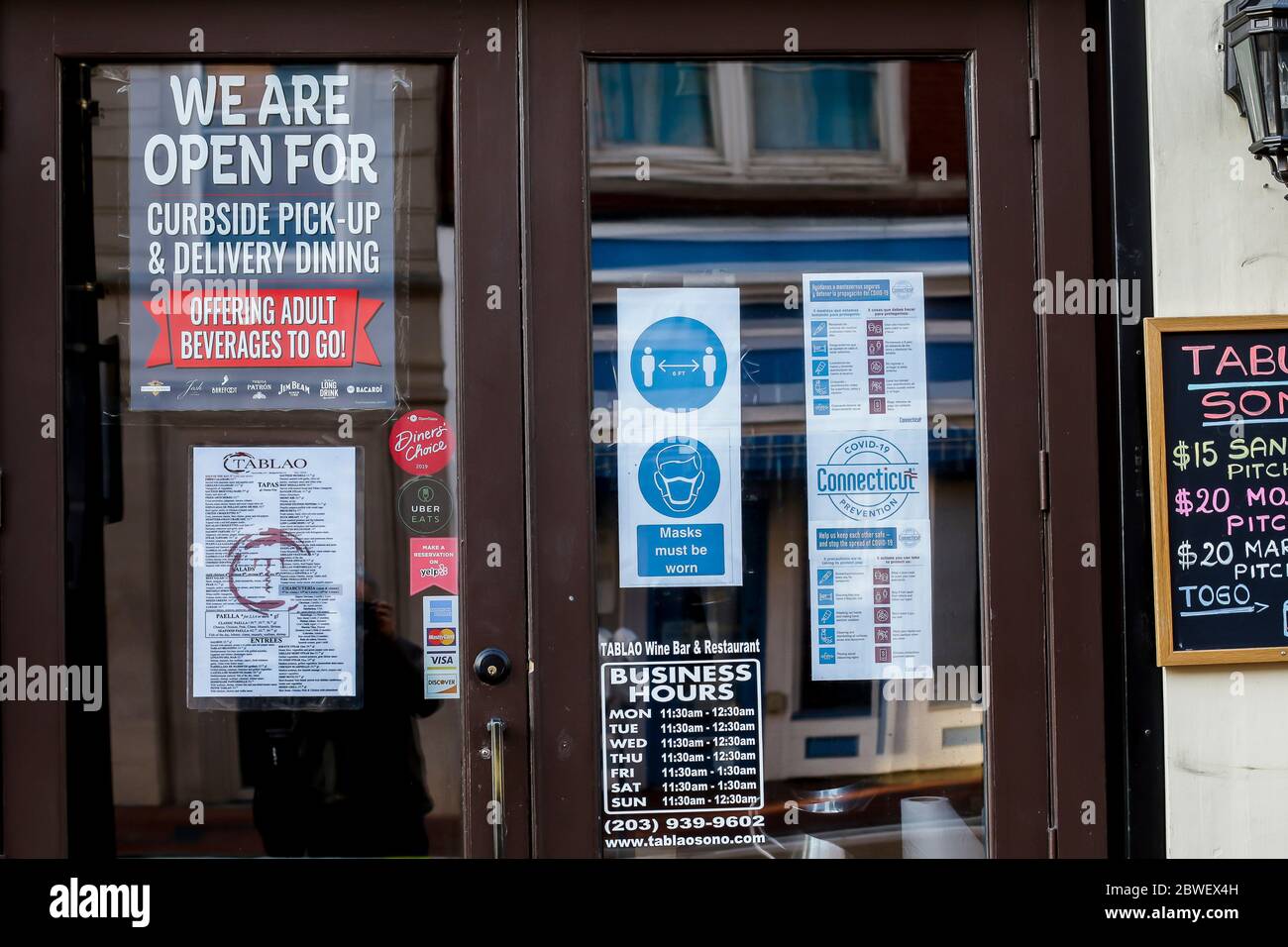 NORWALK, CT, USA - 31 MAI 2020 : panneaux d'information sur la porte d'entrée du restaurant Tablo Wine and Bar pendant la pandémie de COVID-19 Banque D'Images