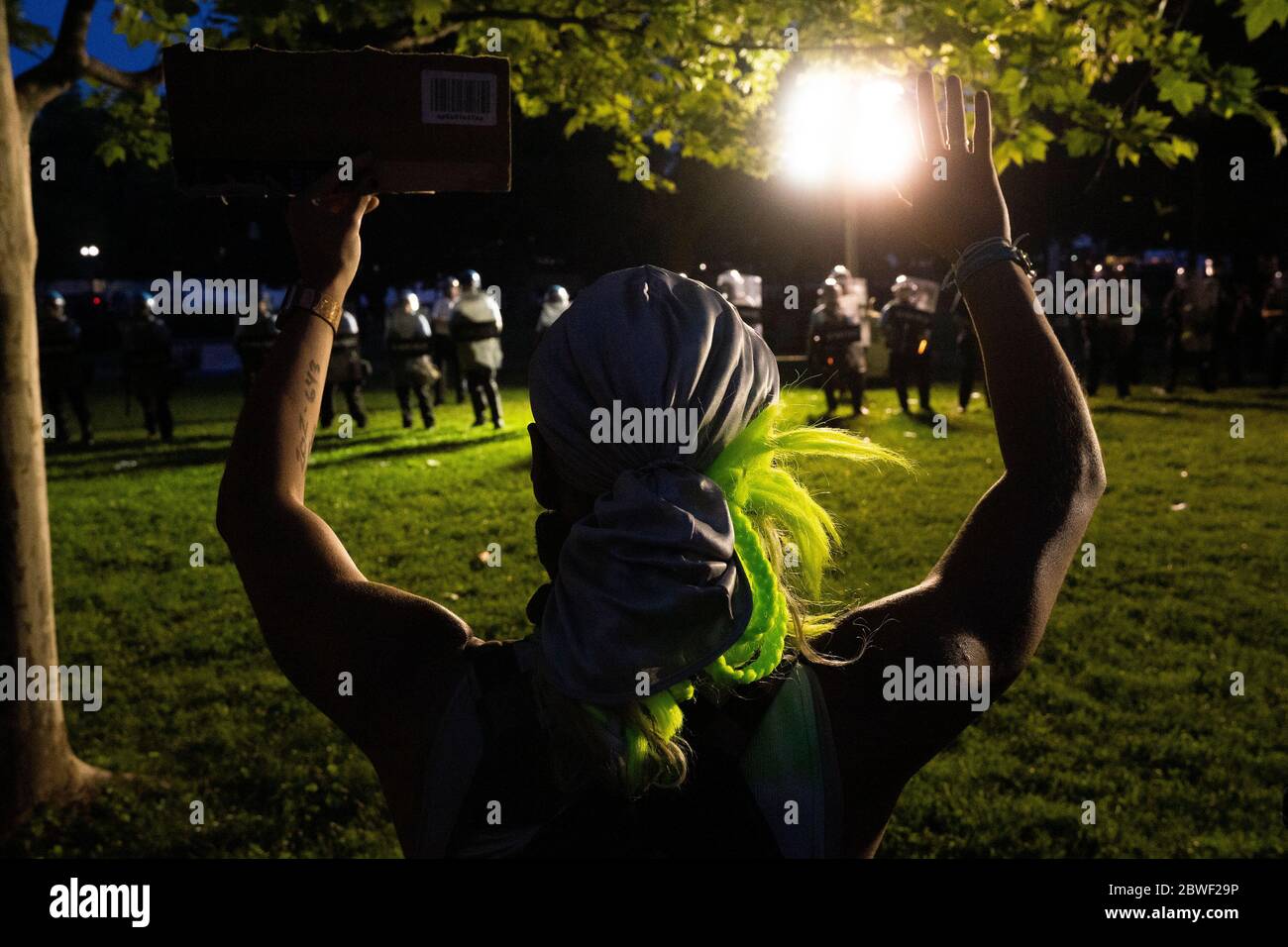 Un manifestant tient la main dans les airs pendant que la police et la Garde nationale regardent lors d'une manifestation à Lafayette Square à Washington, DC, États-Unis, le dimanche 31 mai 2020, après la mort d'un homme noir non armé aux mains de la police du Minnesota, le 25 mai 2020. Crédit : Stefani Reynolds/CNP/MediaPunch Banque D'Images