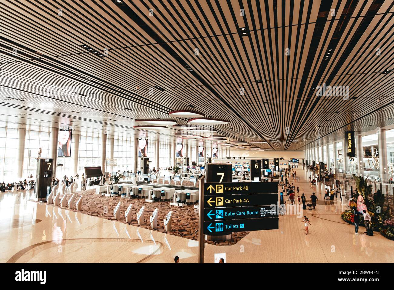 Singapour, aéroport de Changi, novembre 19 : intérieur moderne du terminal 4 rempli de touristes. Panneau indiquant les directions vers le parking, les toilettes et les services de garde d'enfants Banque D'Images