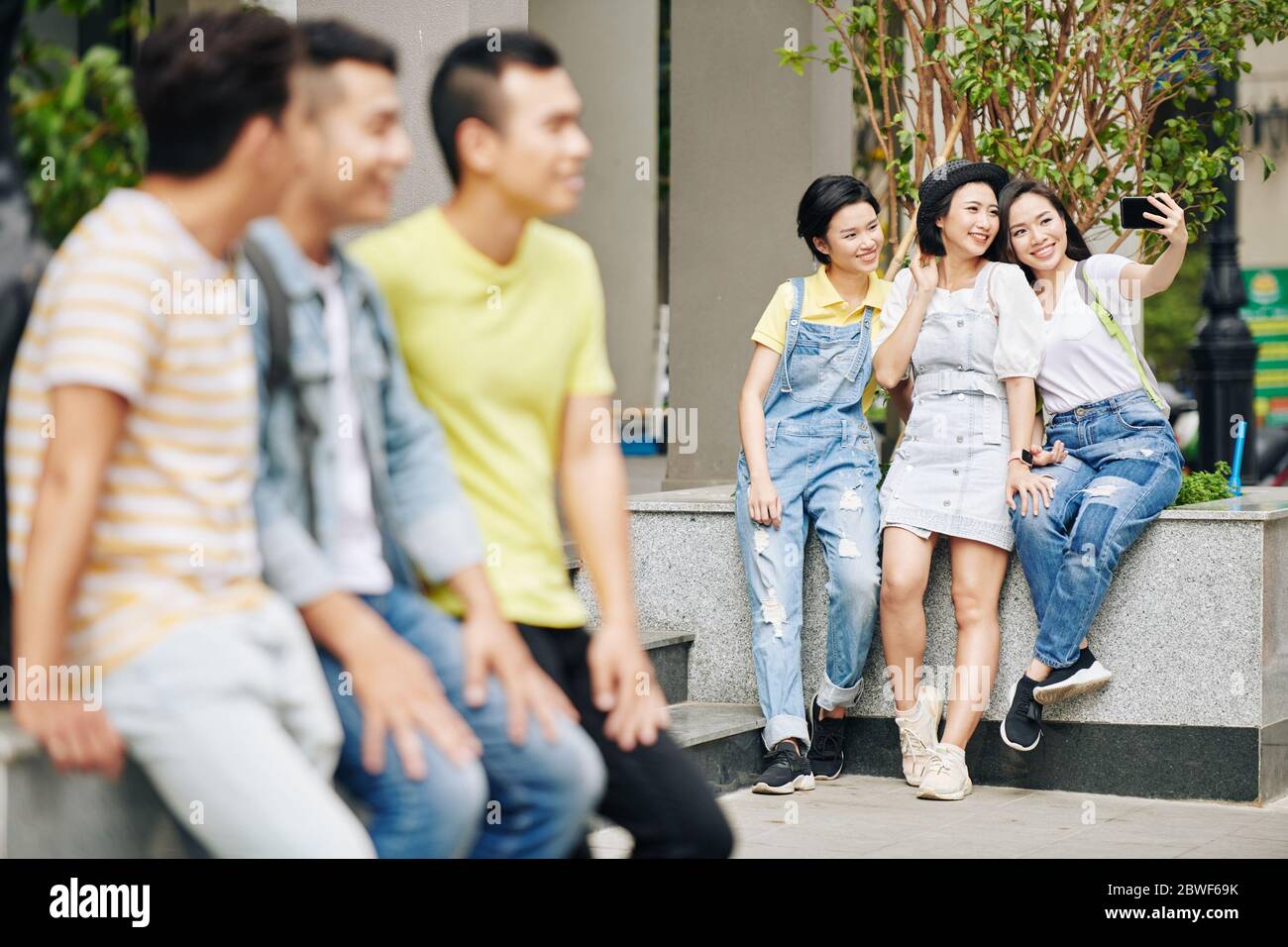 De jeunes étudiants asiatiques souriants prennent leur selfie sur le campus Banque D'Images
