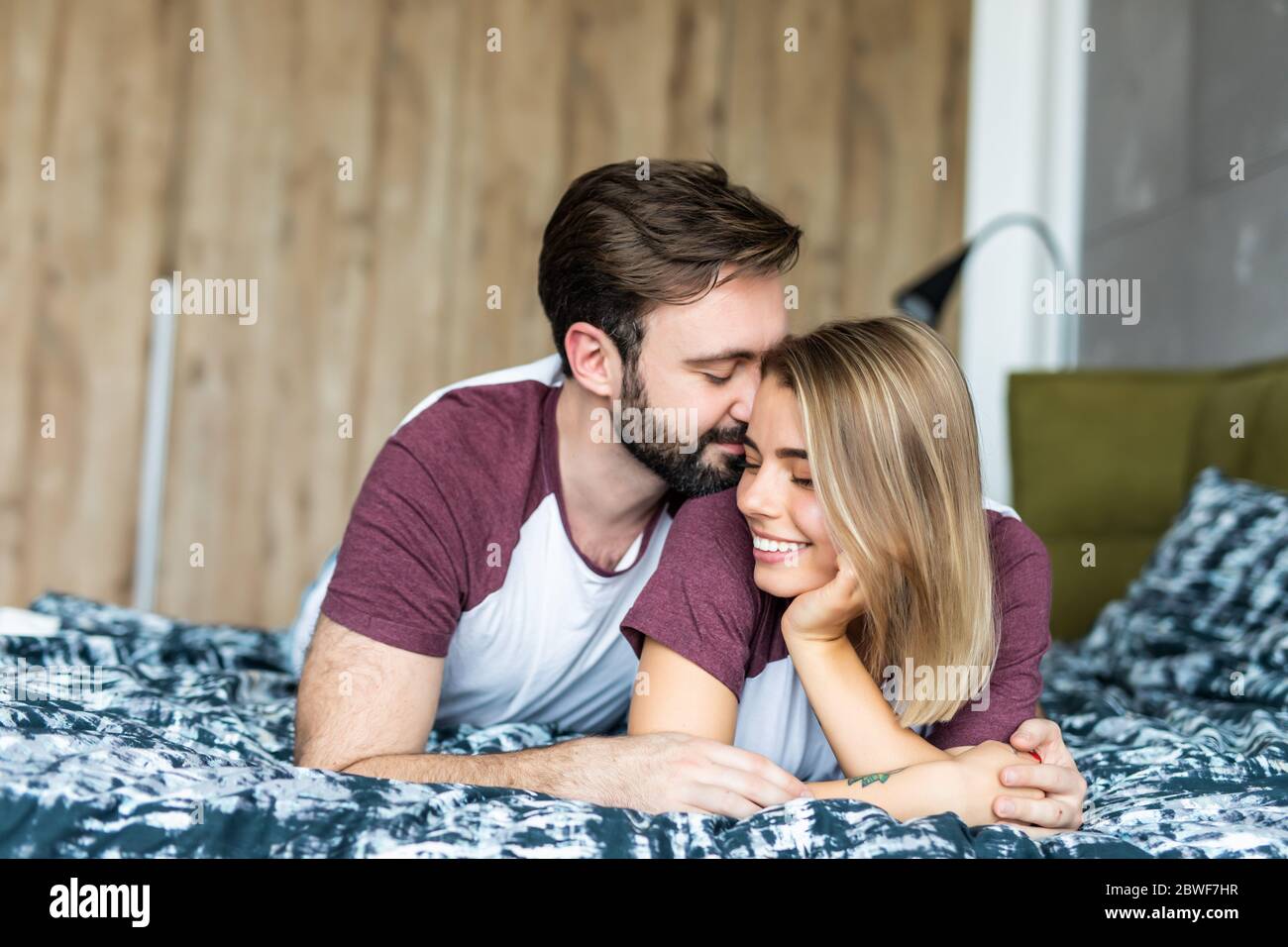 Couple caucasien allongé sur le lit ensemble Banque D'Images